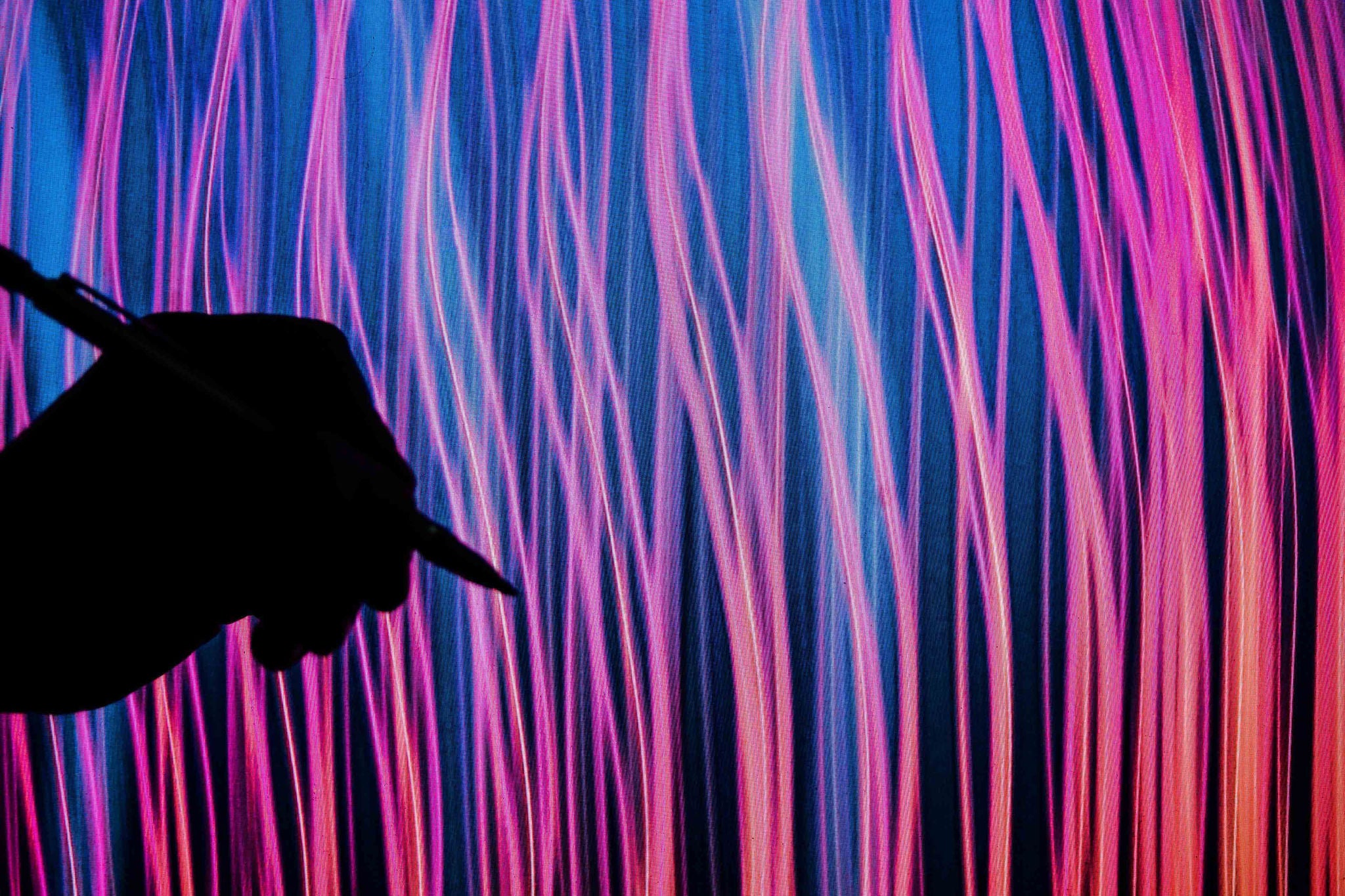 CLOSE-UP OF A HUMAN HAND WITH PEN AGAINST LIGHT