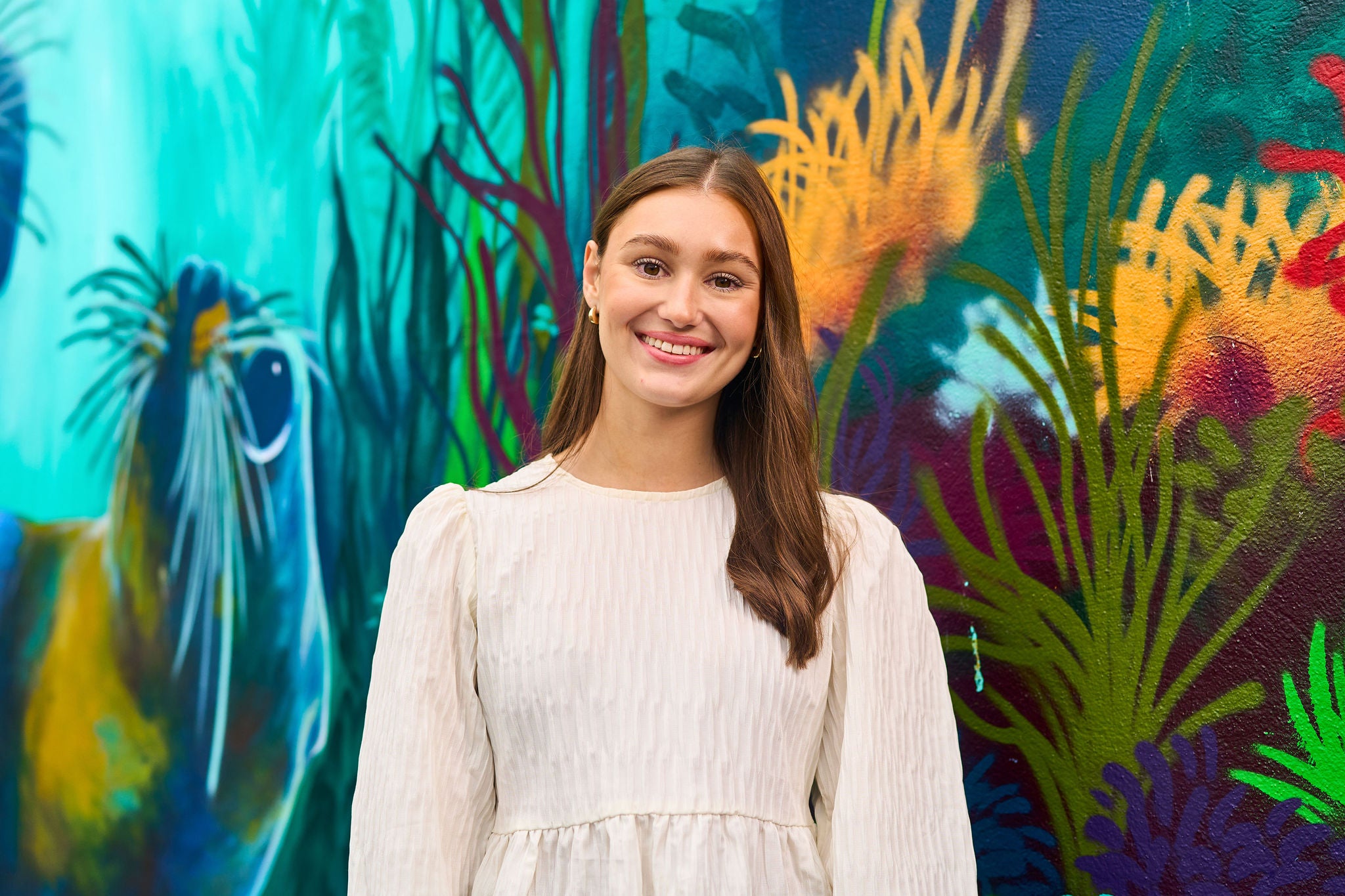 Person standing before a colorful mural