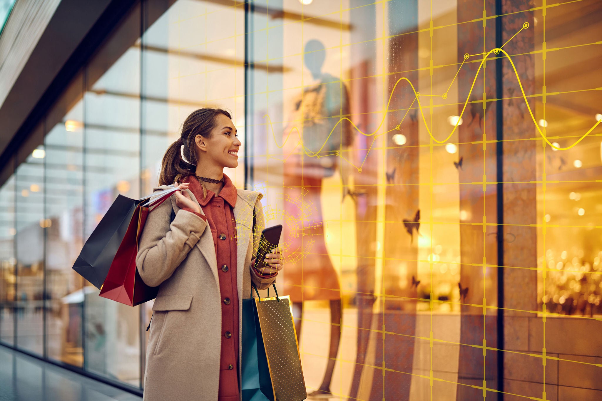 Happy woman with shopping bags looking at store windows while walking through city