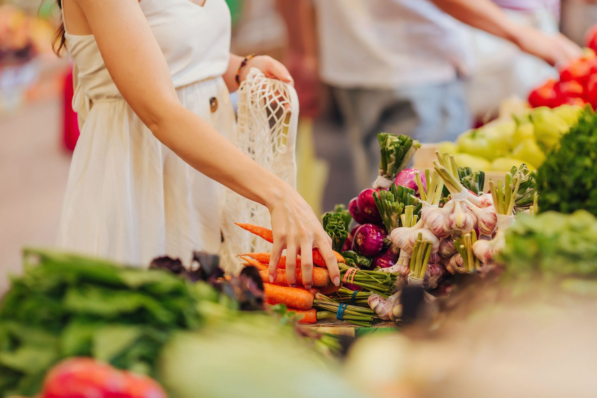 Selecting fresh vegetables from a market stall