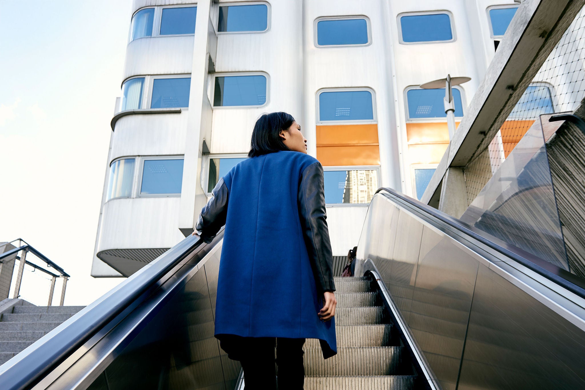 Woman standing on escalator