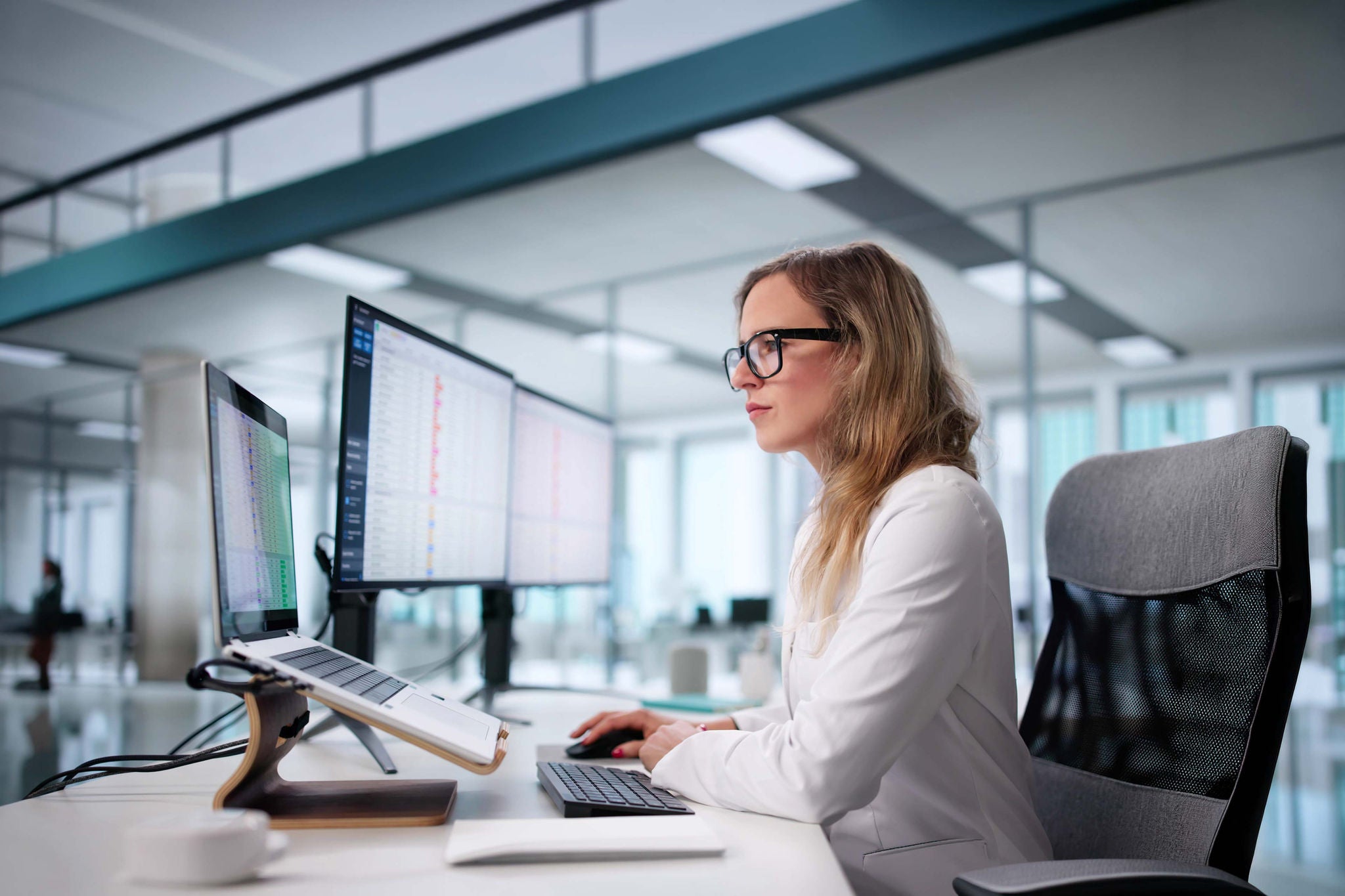 Frau arbeitet am Computer mit mehreren Monitoren