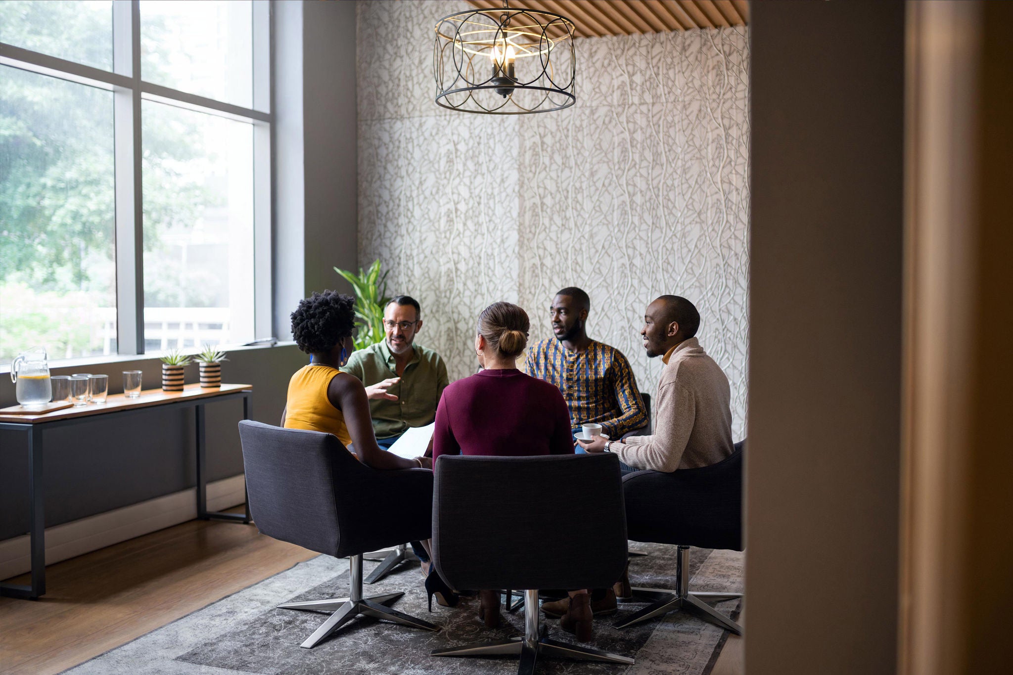 Diverse group of businesspeople having a casual meeting together in the lounge area of an office