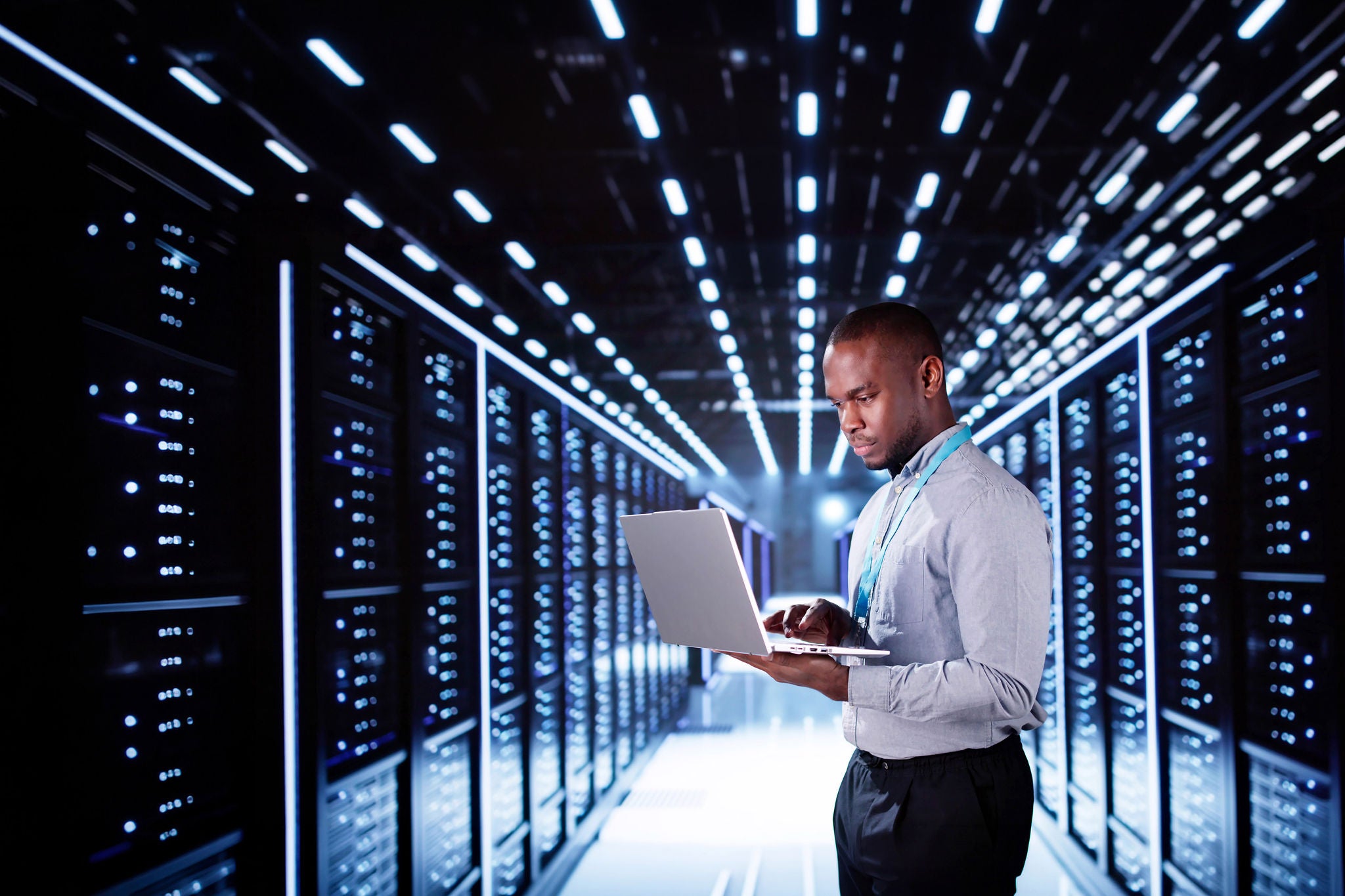 Happy Engineer In Data Center Server Room Configuring AI Technology
