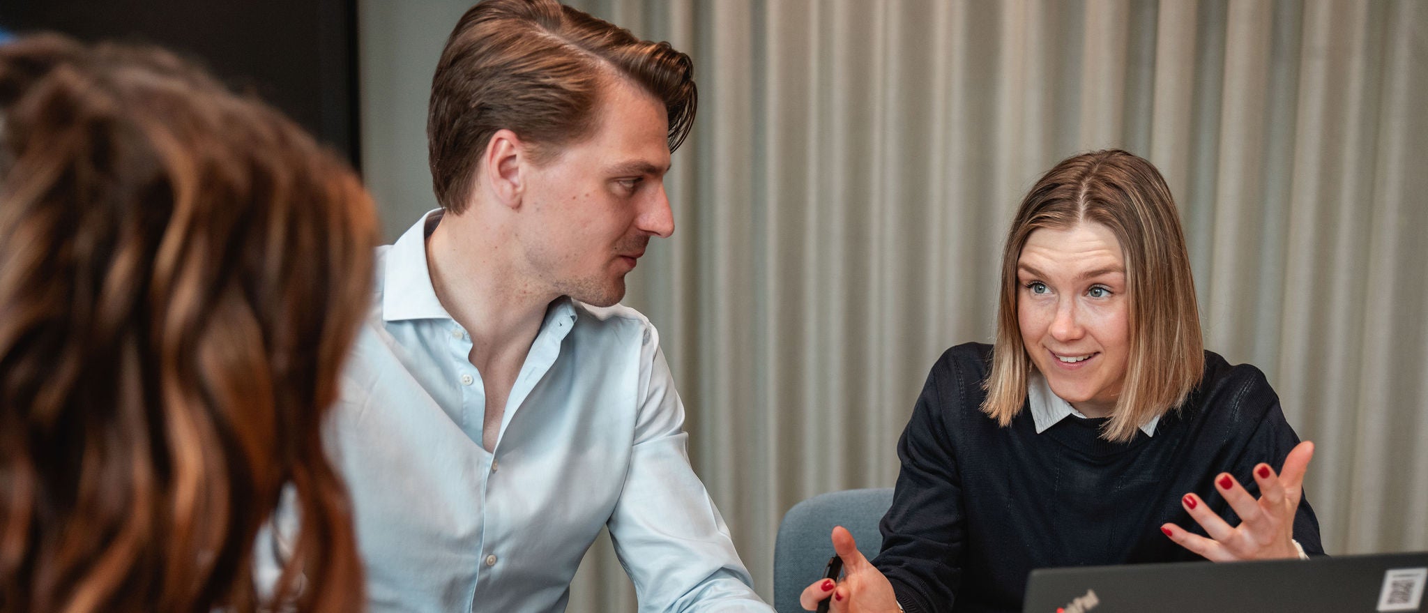 Professionals discussing ideas during an active team meeting in office