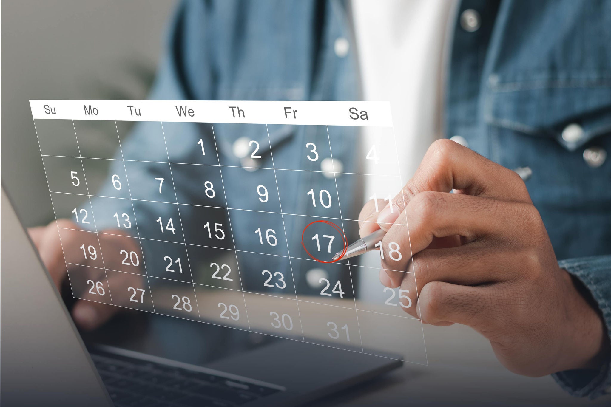 A smiling young woman with headphones and folders, standing outdoors on a college campus.