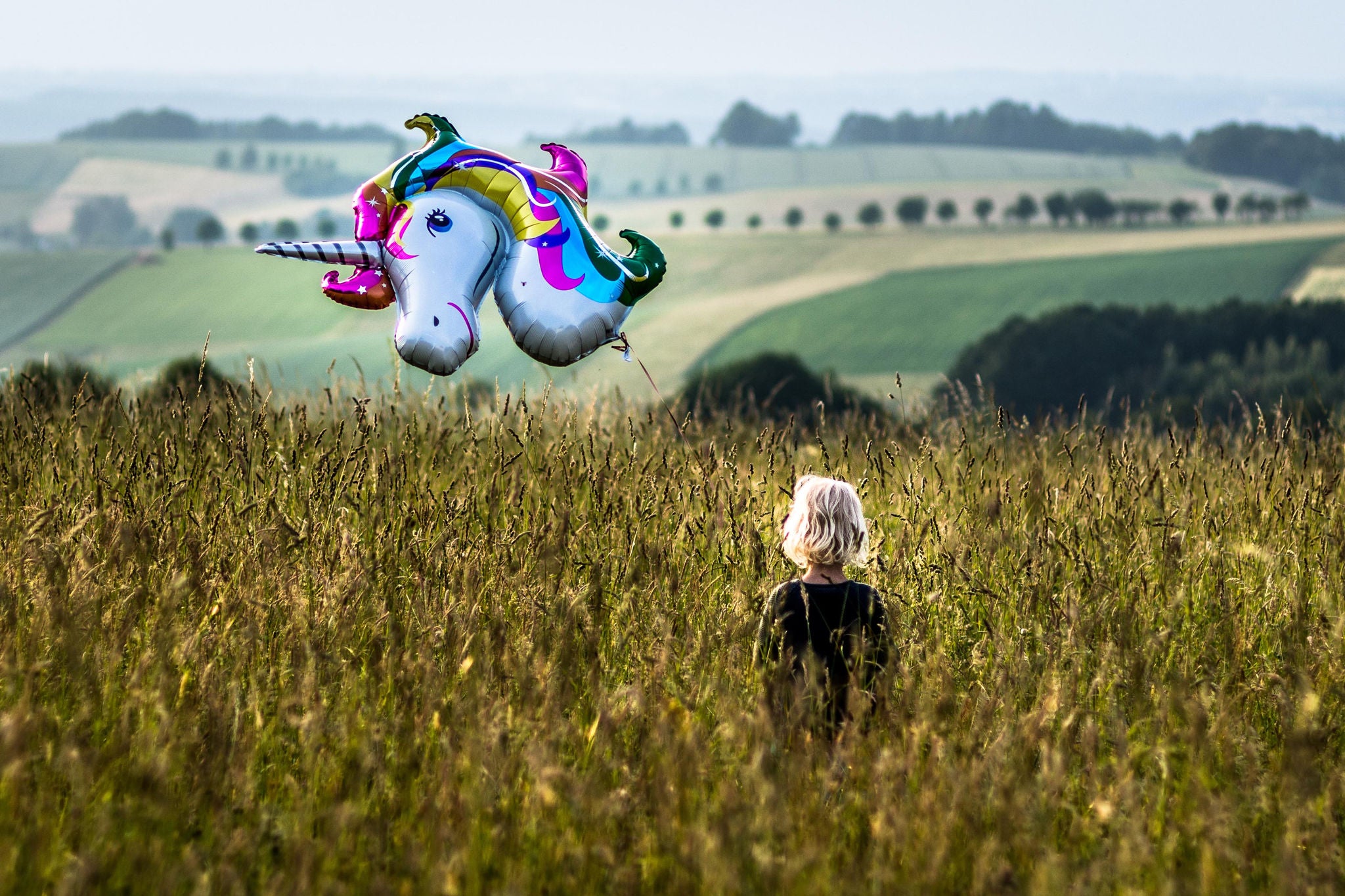 Barn står på en mark med en ballon i hånden