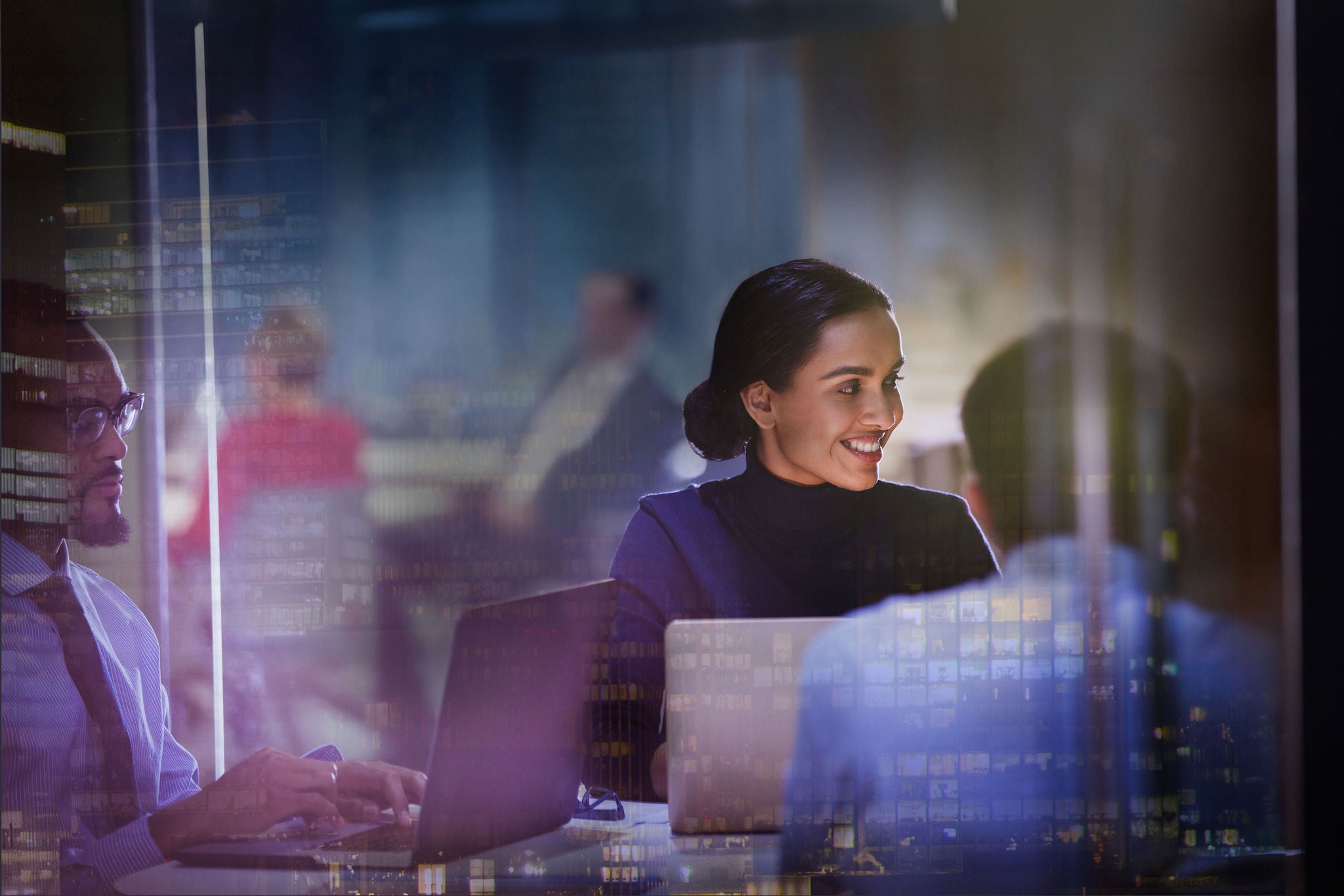 Businesswoman at laptop in meeting in highrise office