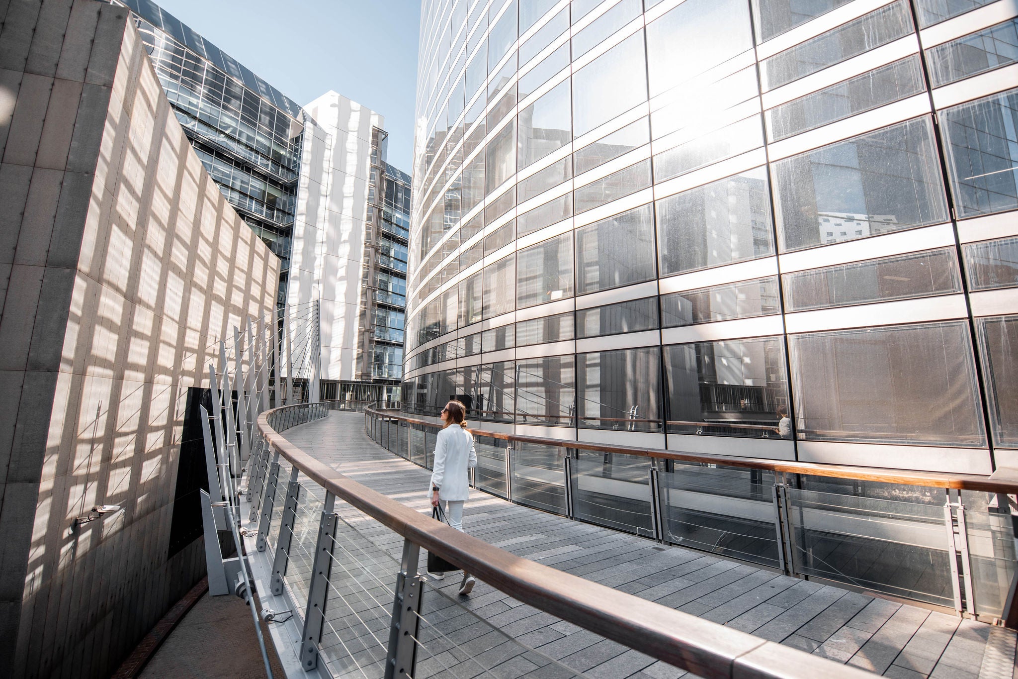 Business woman walking outdoors at the financial district with modern buildings on the background in Paris