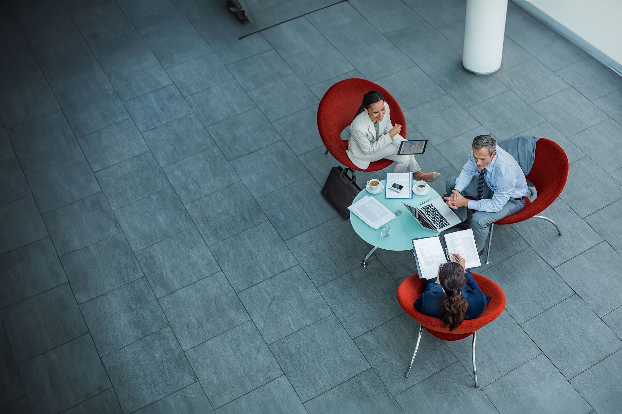 High angle view of businesspeople discussing strategy at coffee table in office