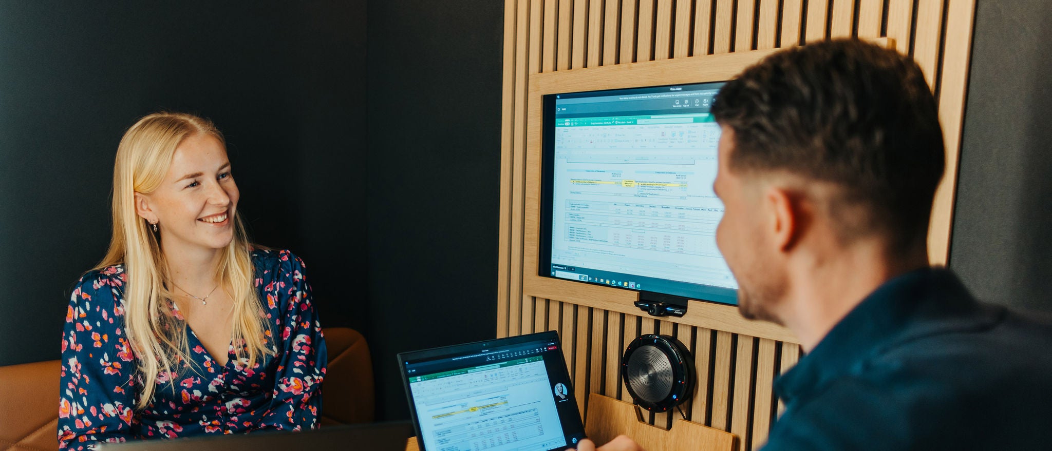 Professionals discussing work while reviewing data on screen in office