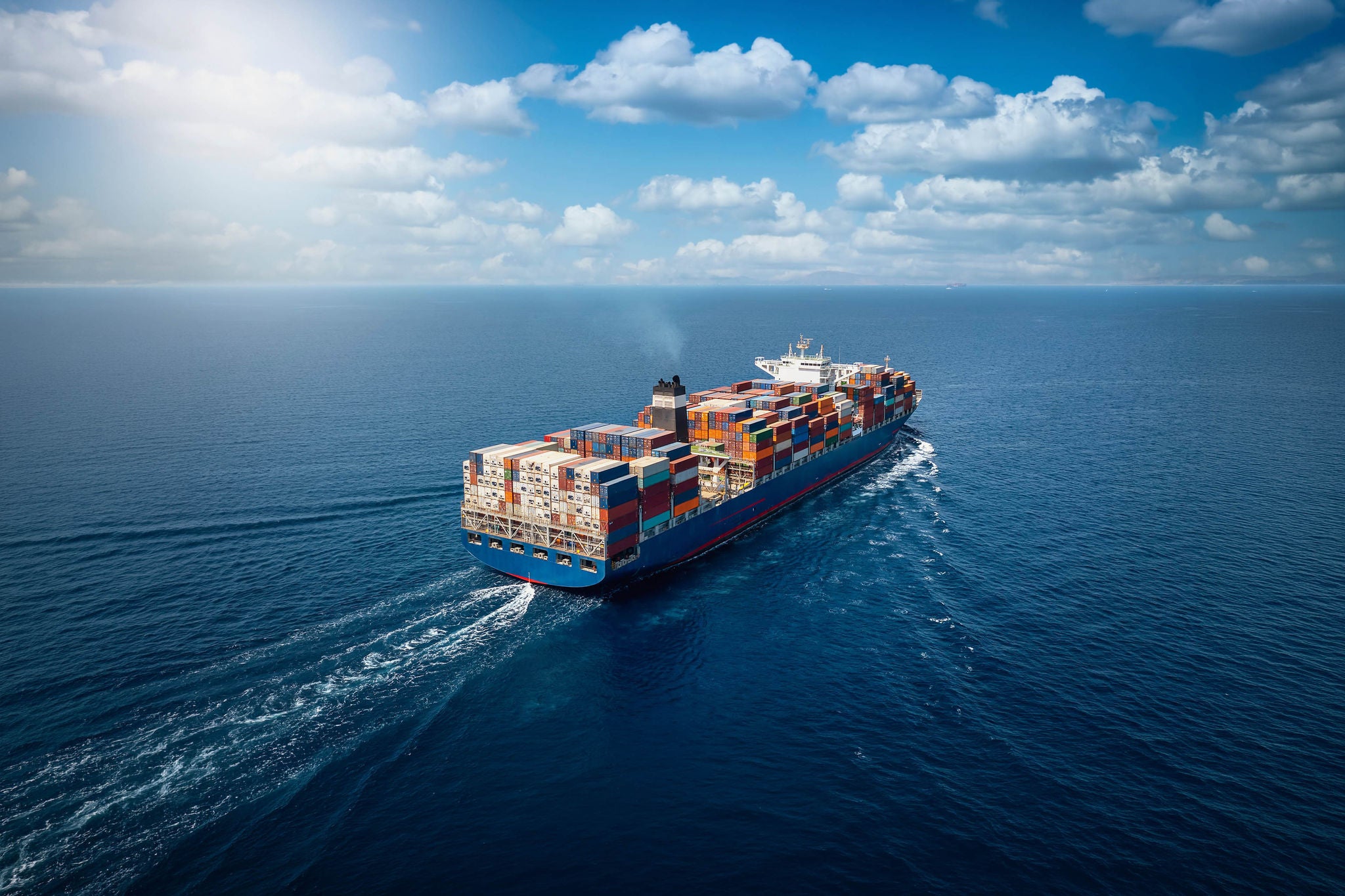A large container cargo ship travels over ocean