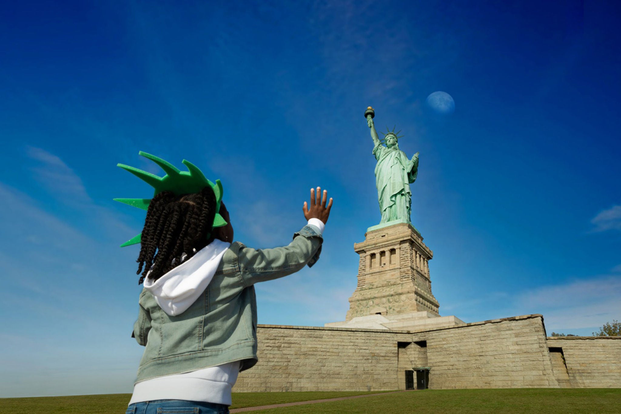 Girl waving at the statue of liberty