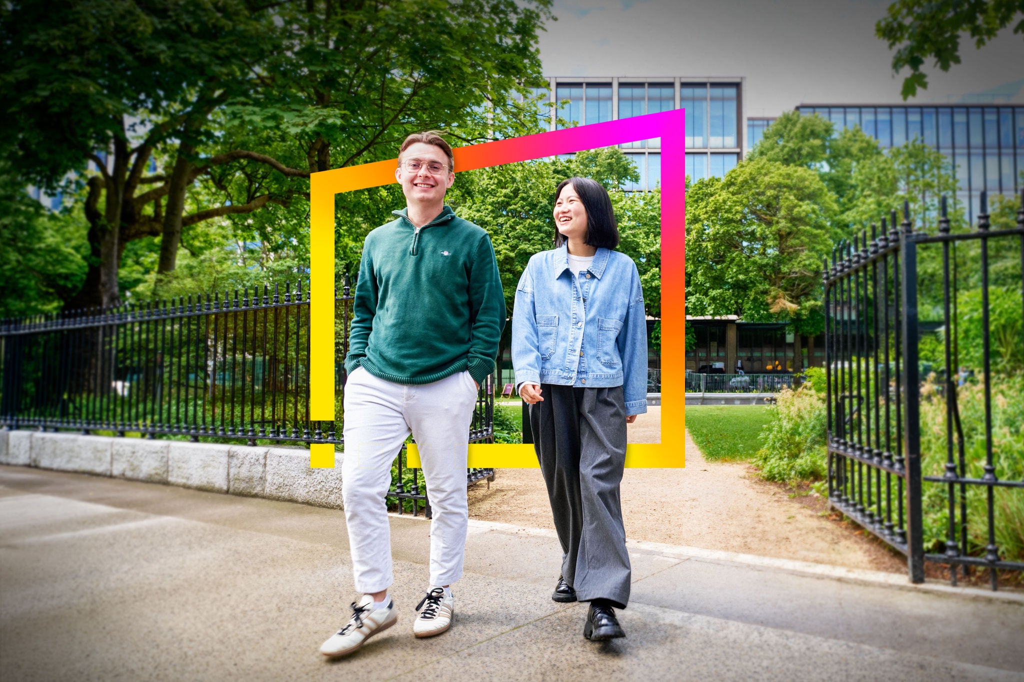 Two people walking through a green campus setting framed by a colorful geometric graphic.
