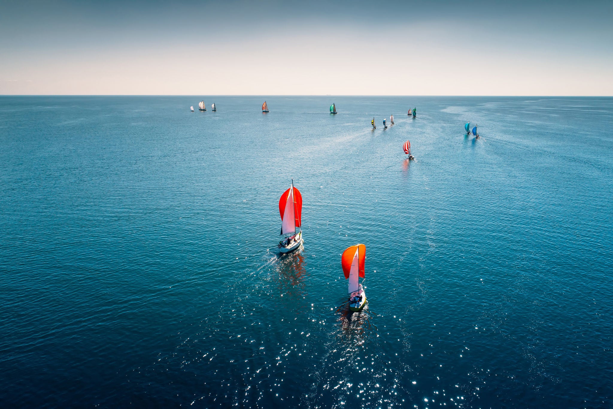 Regatta sailing ship with red sails on open sea