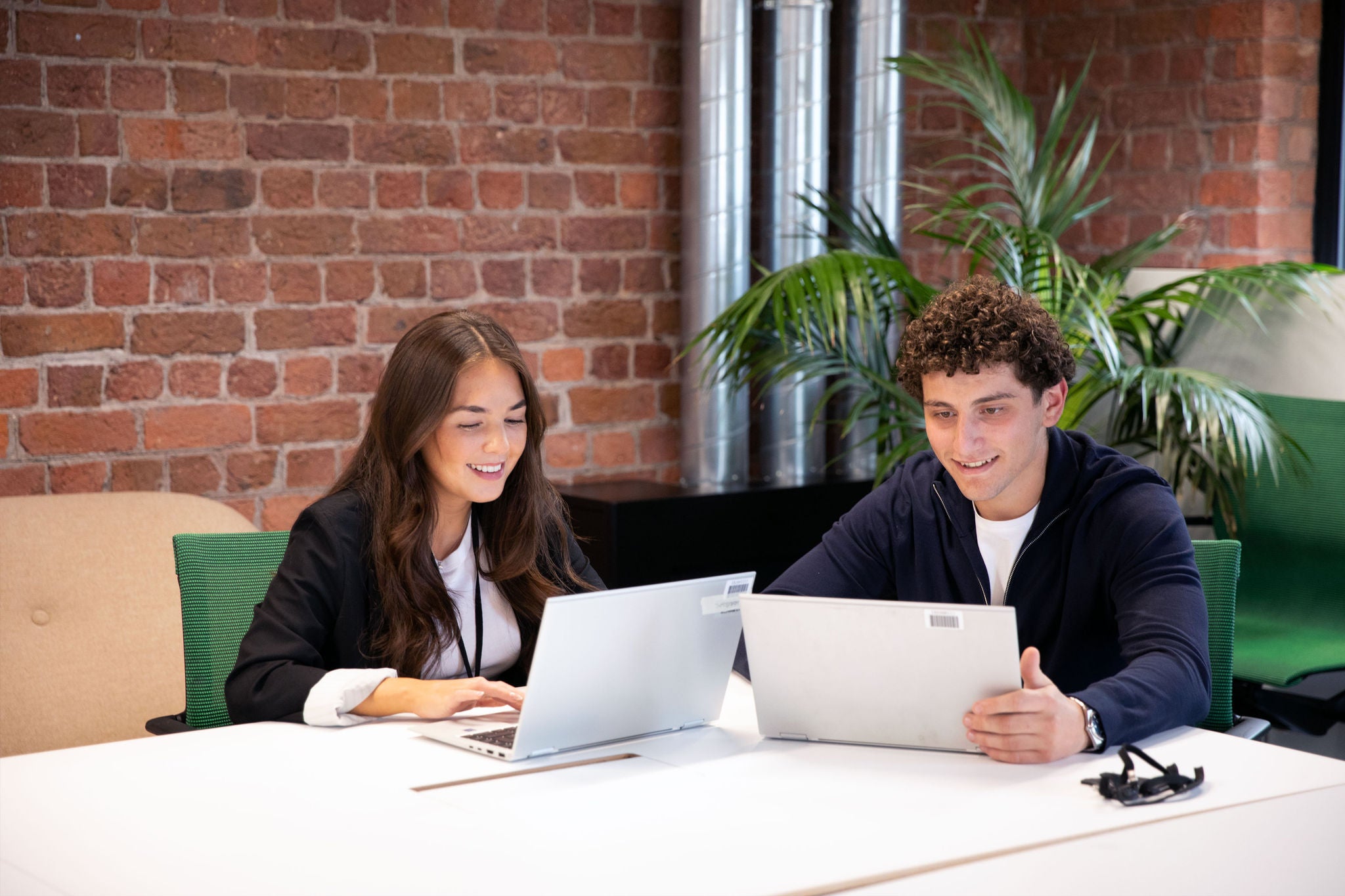 Two people working on laptops