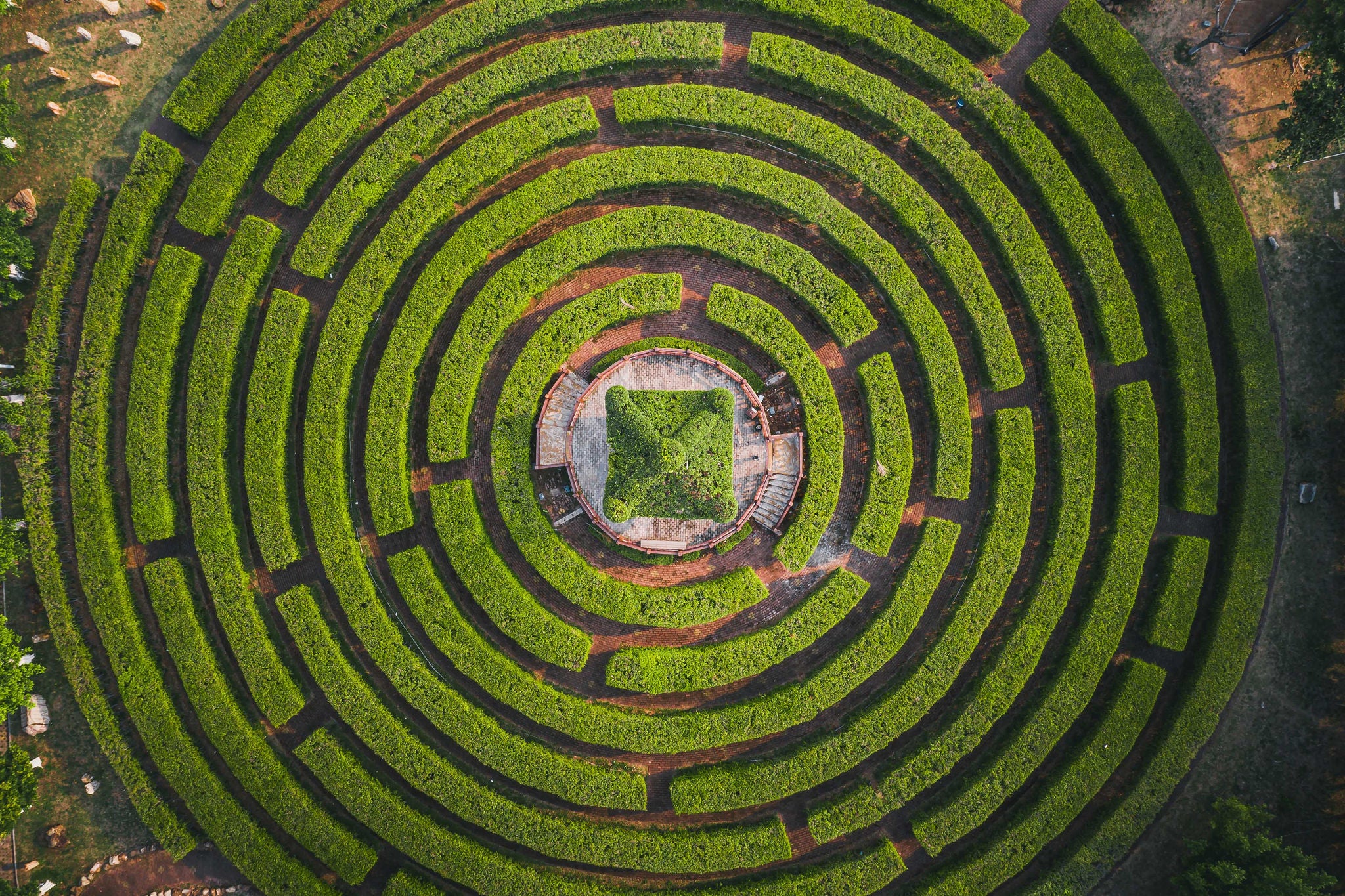 Aerial view of a circular garden maze and green pavilion