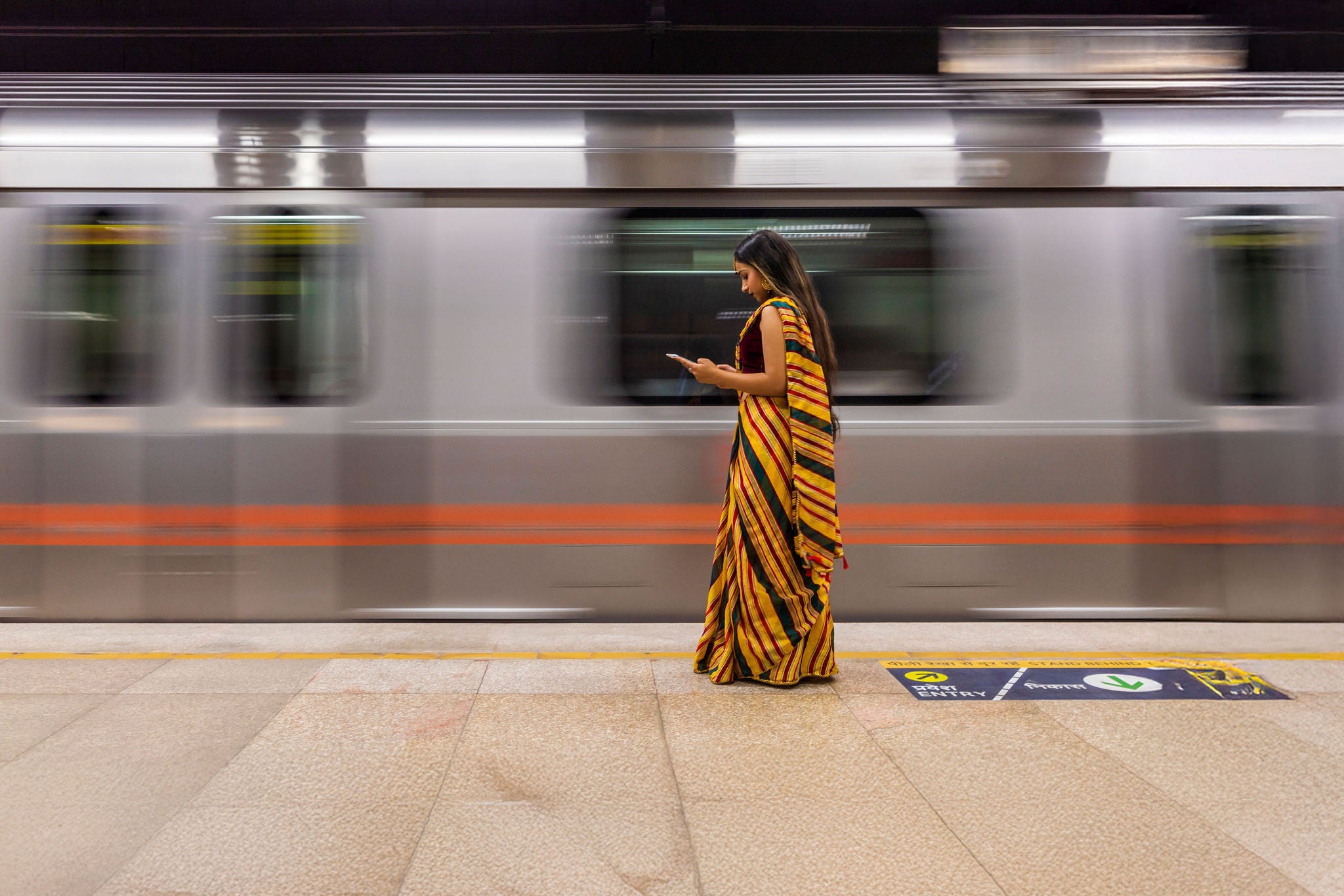 Indisches Mädchen benutzt ein digitales Tablet in einer U-Bahn-Station