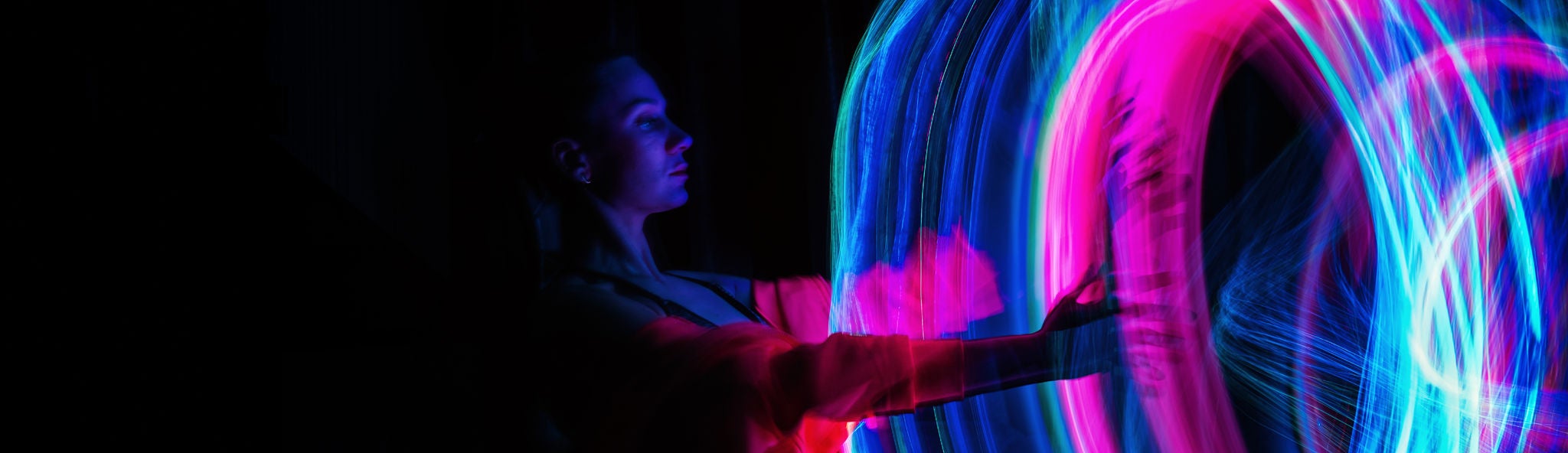 Leuchtende Neonlichter formen dynamische Muster in einer dunklen Umgebung.