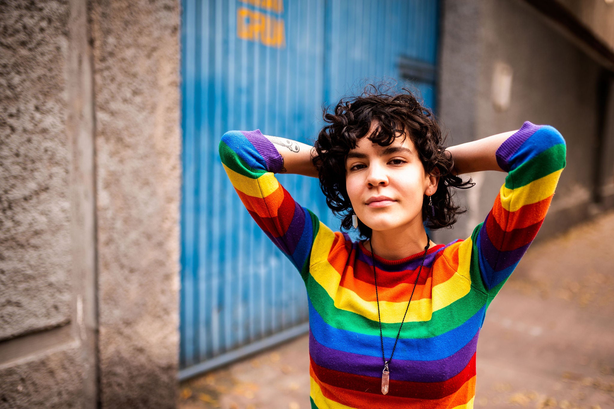 Portrait of a smiling Mexican woman wearing rainbow sweater