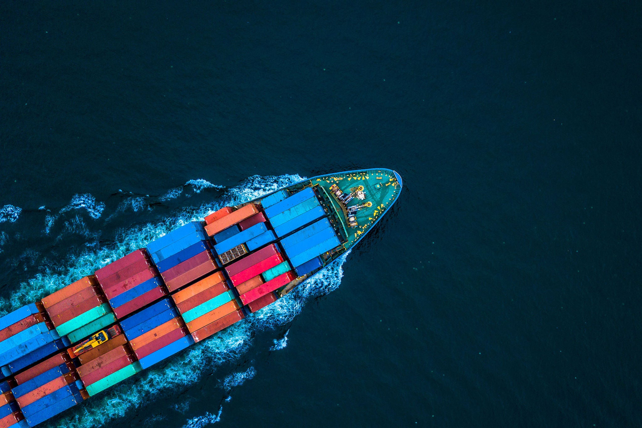 Flyfoto av et containerskip som frakter last på åpent hav