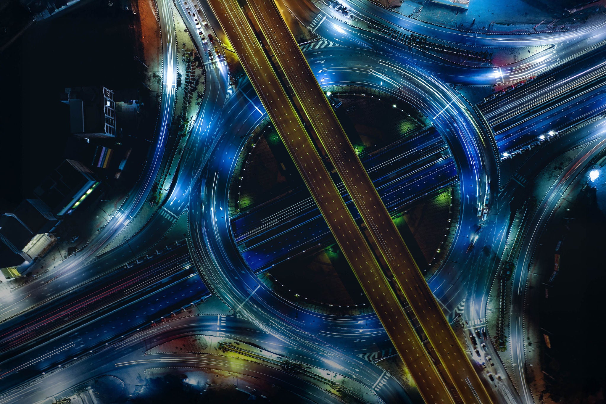 Aerial top view of smart modern transportation with Expressway, Road and Roundabout, busy highway traffic night time. Vehicles moving. Important infrastructure.