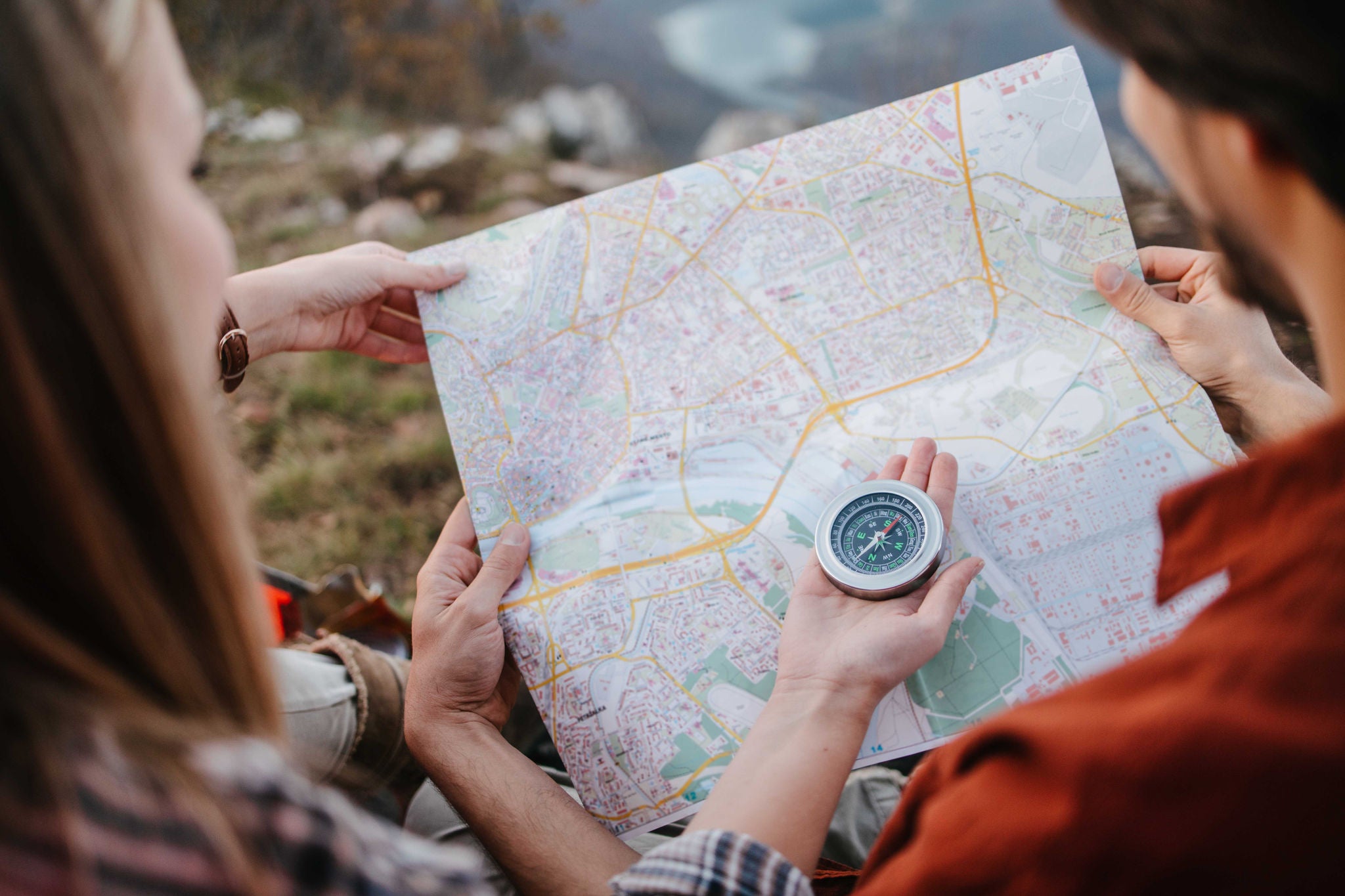 Couple of campers using compass and a map to explore an area