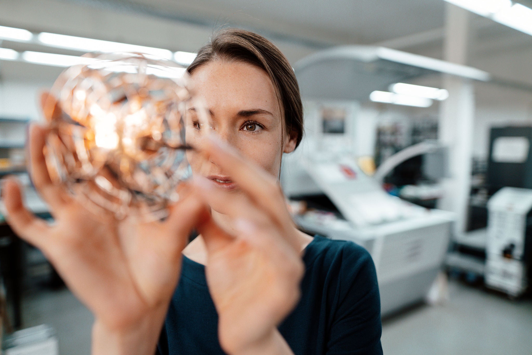 Personne examinant un modele spherique lumineux dans un laboratoire