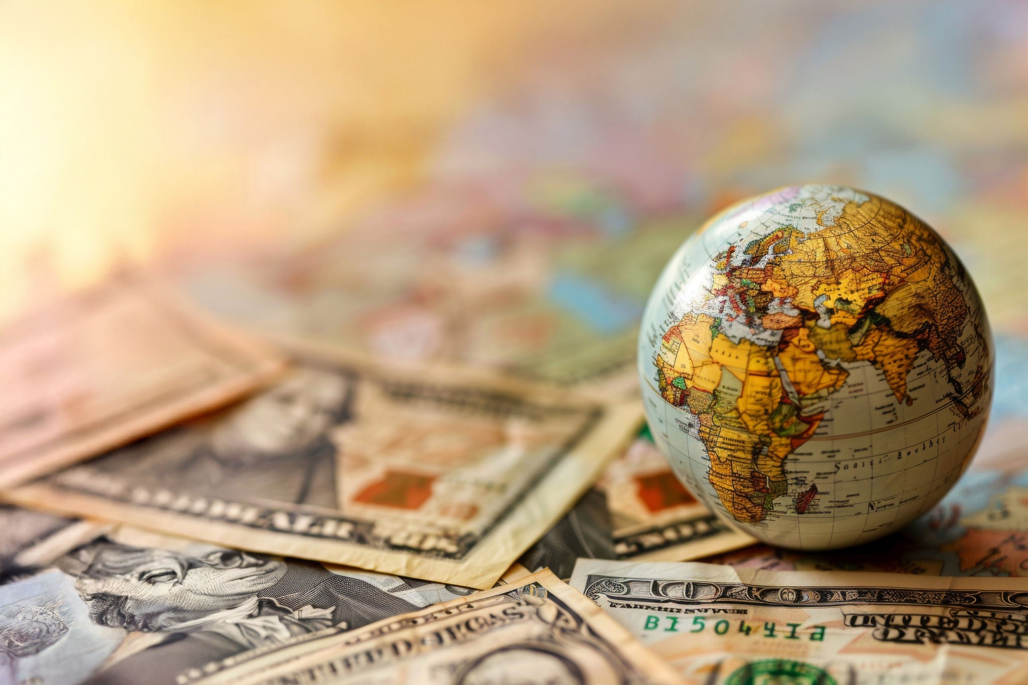 Macro shot of us currency and a miniature globe, representing global financial markets 
