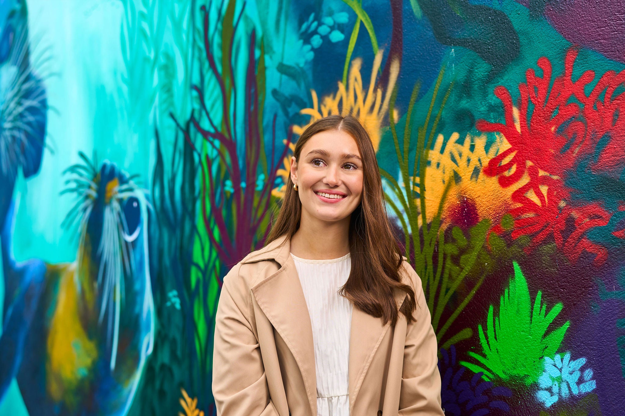 Person standing in front of a colourful wall