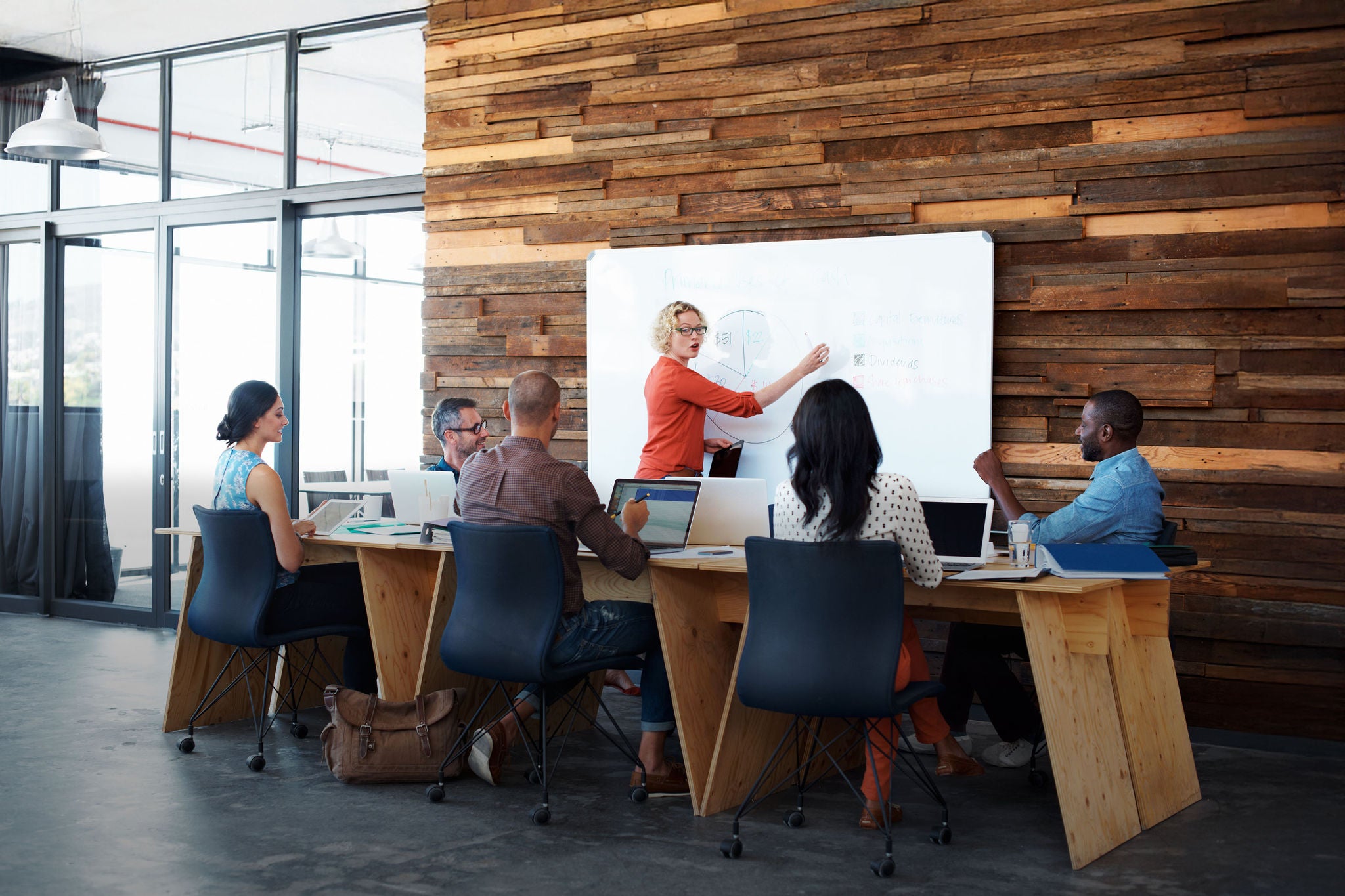 Female office worker giving a financial presentation to her colleagues