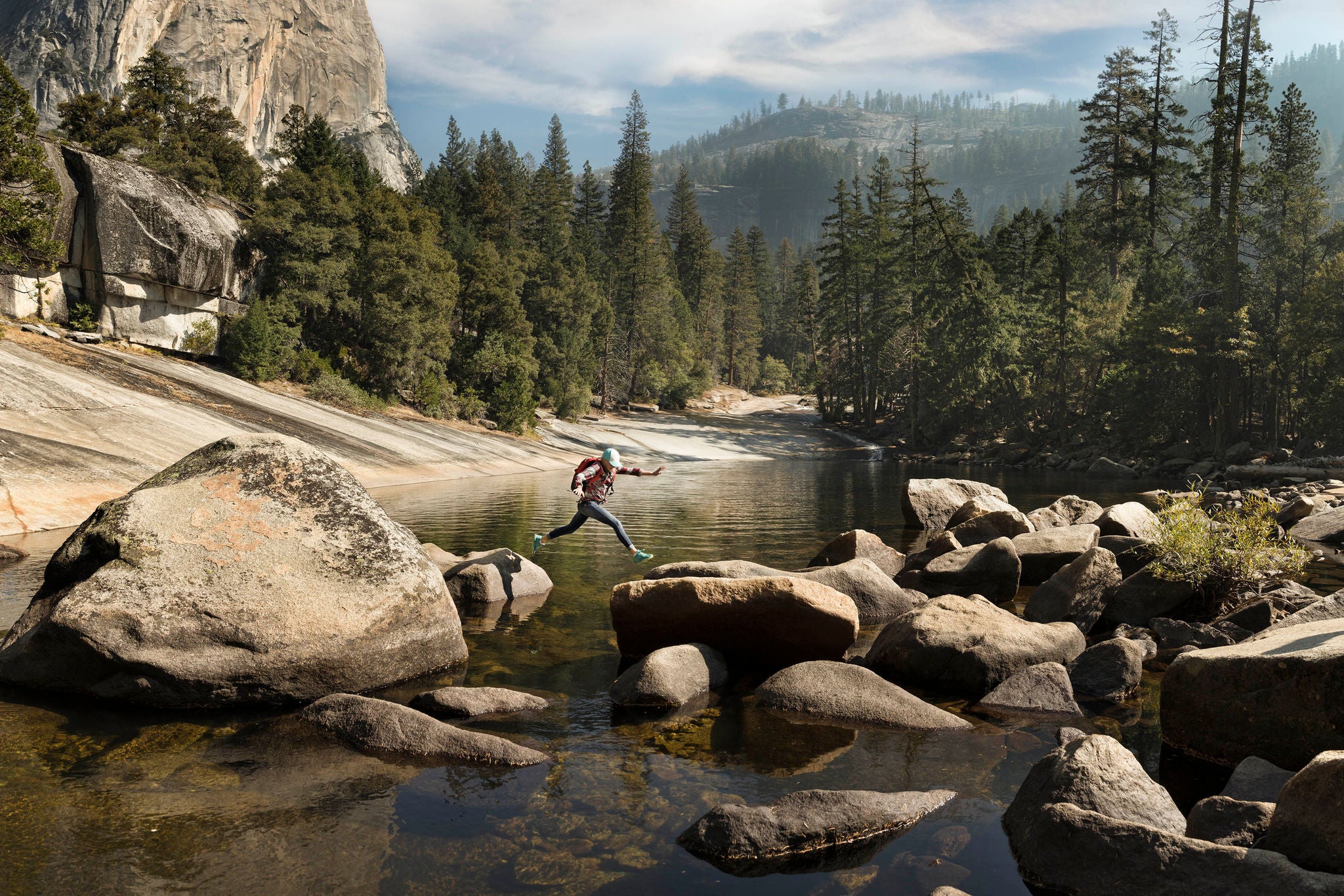 A girl jumping from rock to rock by Emerald Pool above Vernal Falls Yosemite
