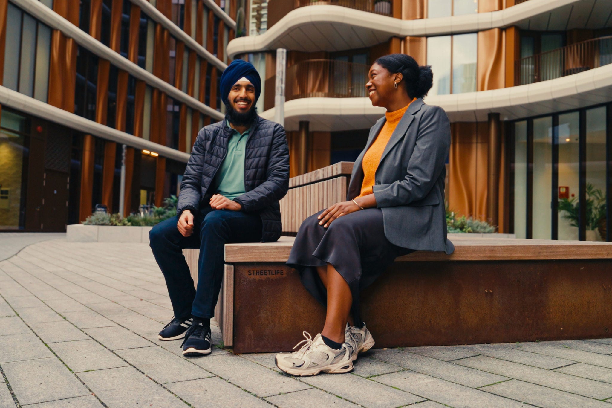 Two colleagues engaged in conversation in a modern courtyard