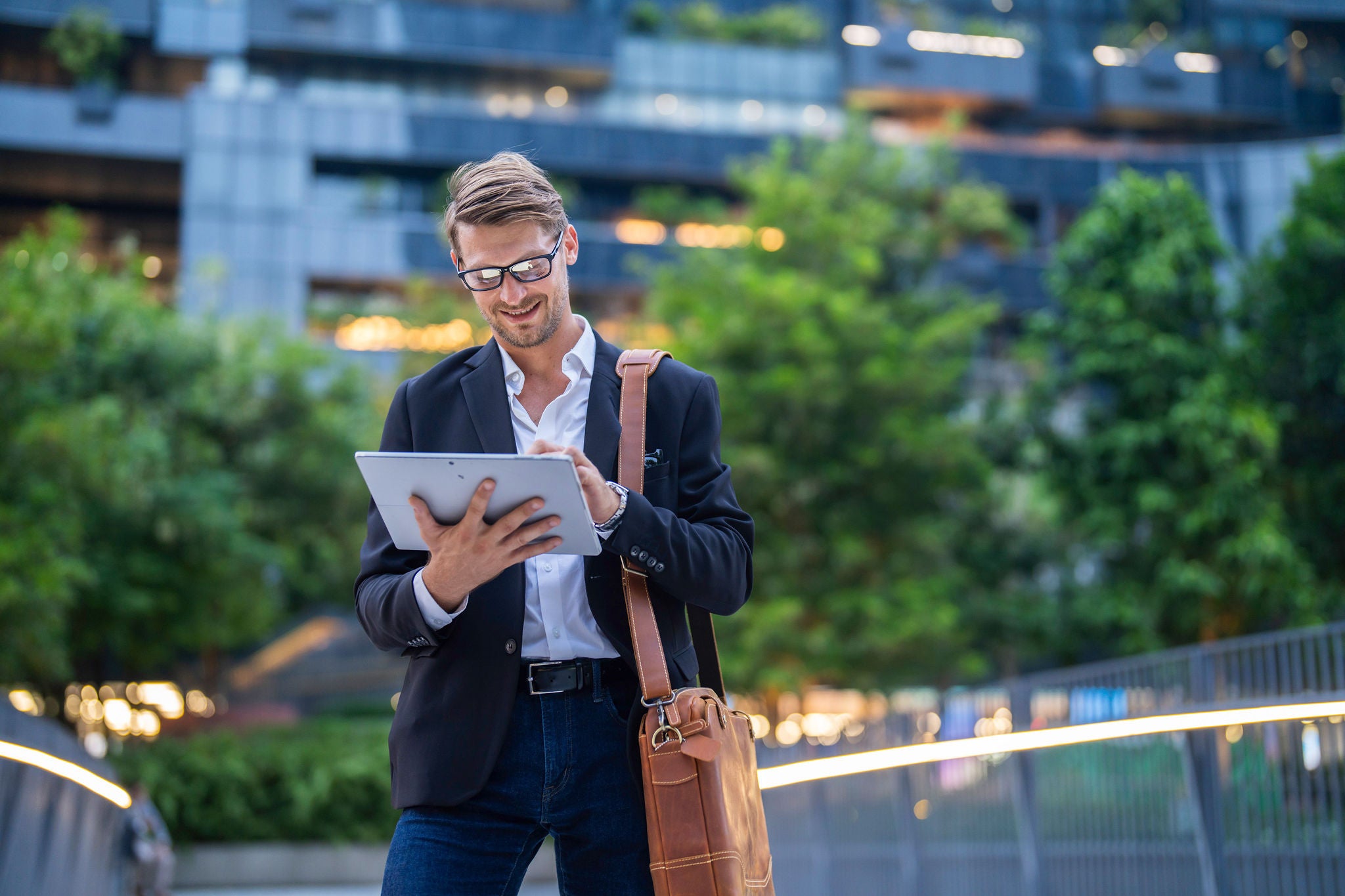 Portrait of businessman in glasses holding tablet