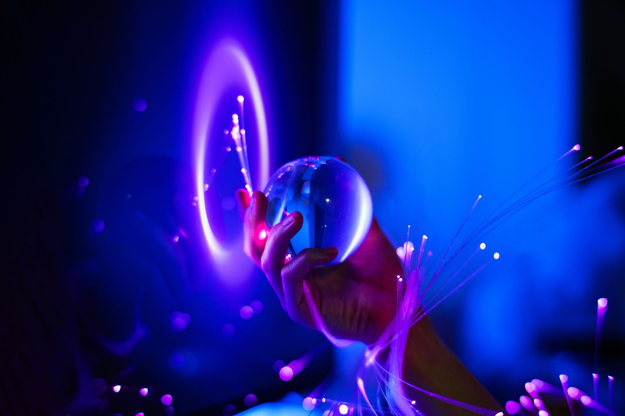Main tenant une sphère lumineuse avec des effets violets et bleus