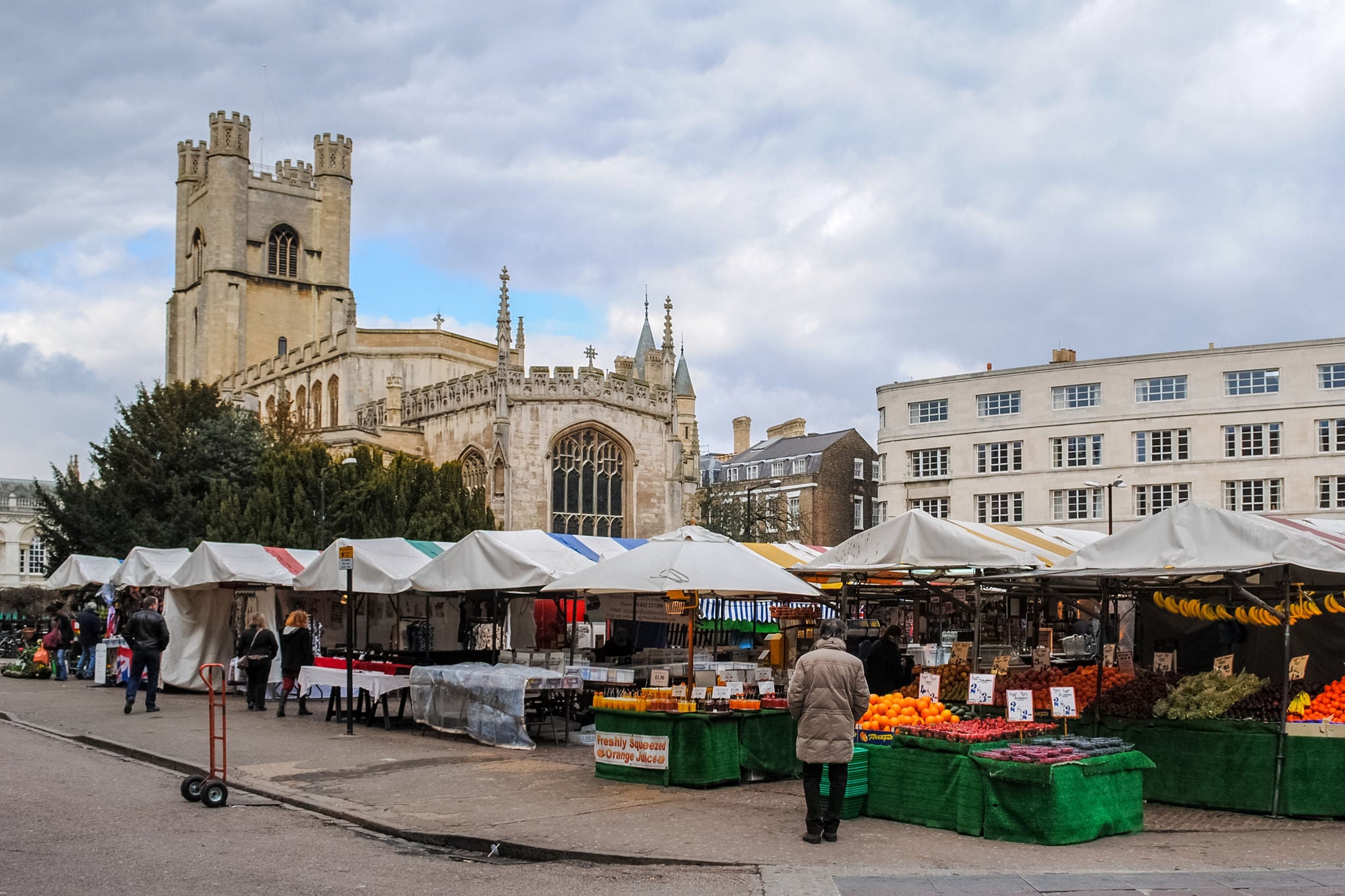 Outdoor market stalls selling fresh produce in a city square