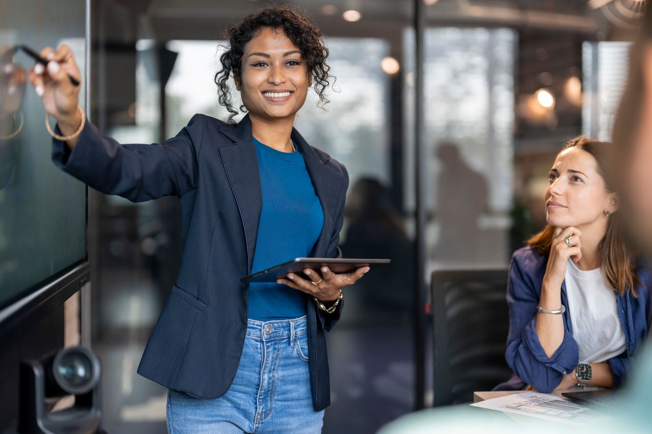 女商務人士在會議室向同事進行簡報