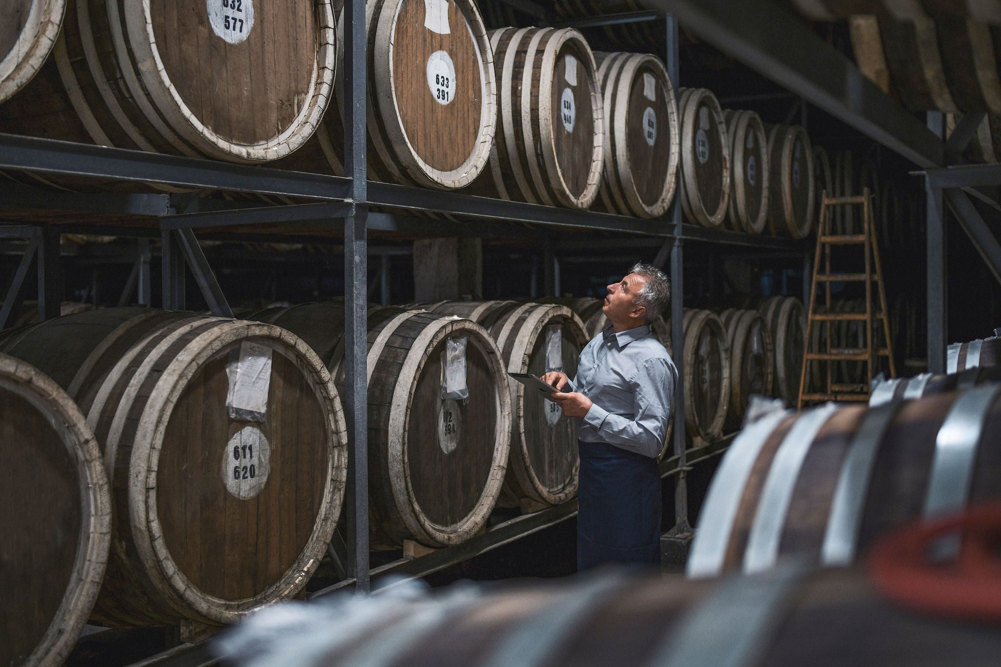 worker Examining barrels in warehouse 