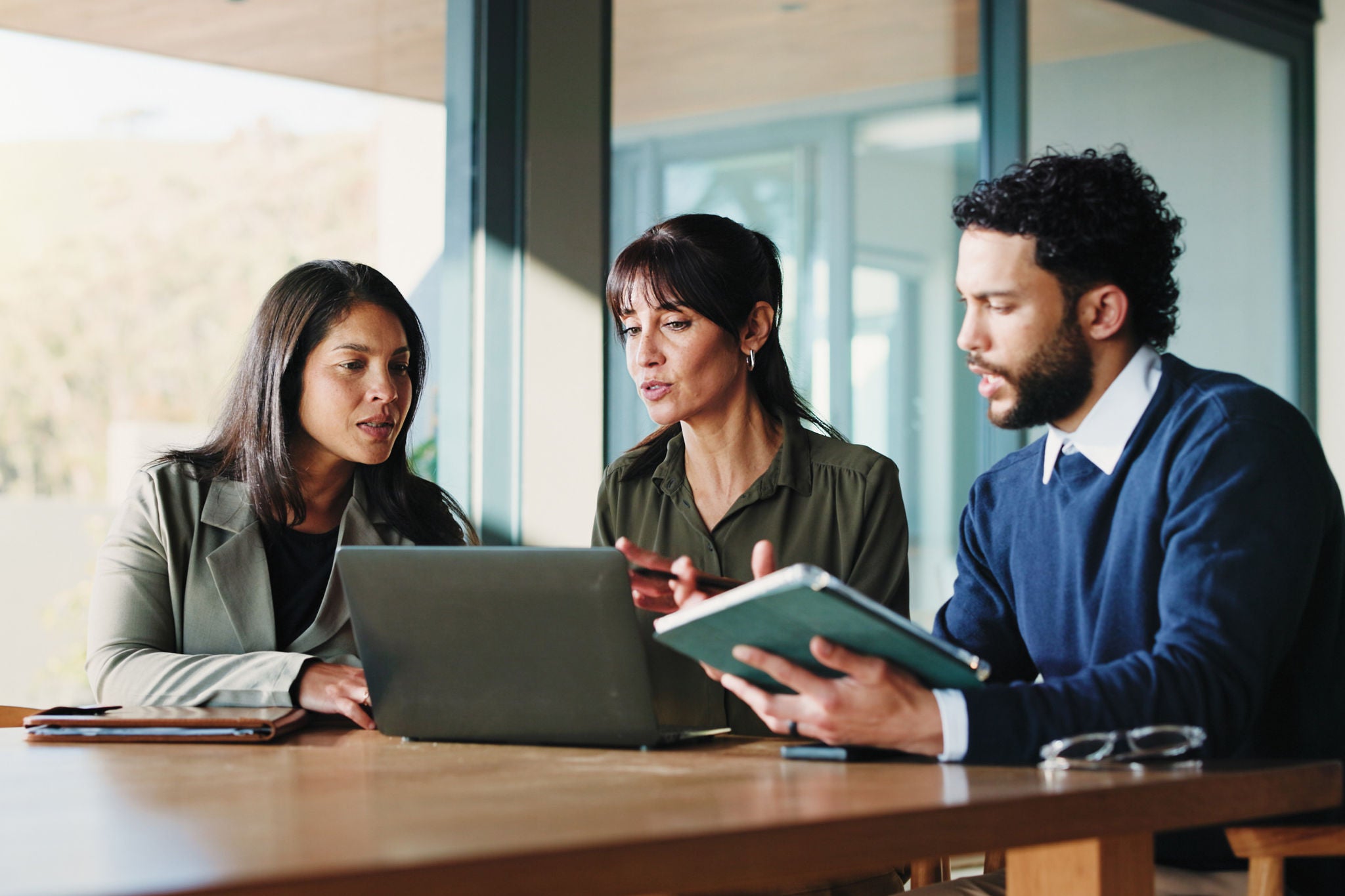 Review, discussion or people in office with laptop, team or project development for client. Collaboration, evaluation or consultant in agency with tablet, contract edit or feedback for stakeholder