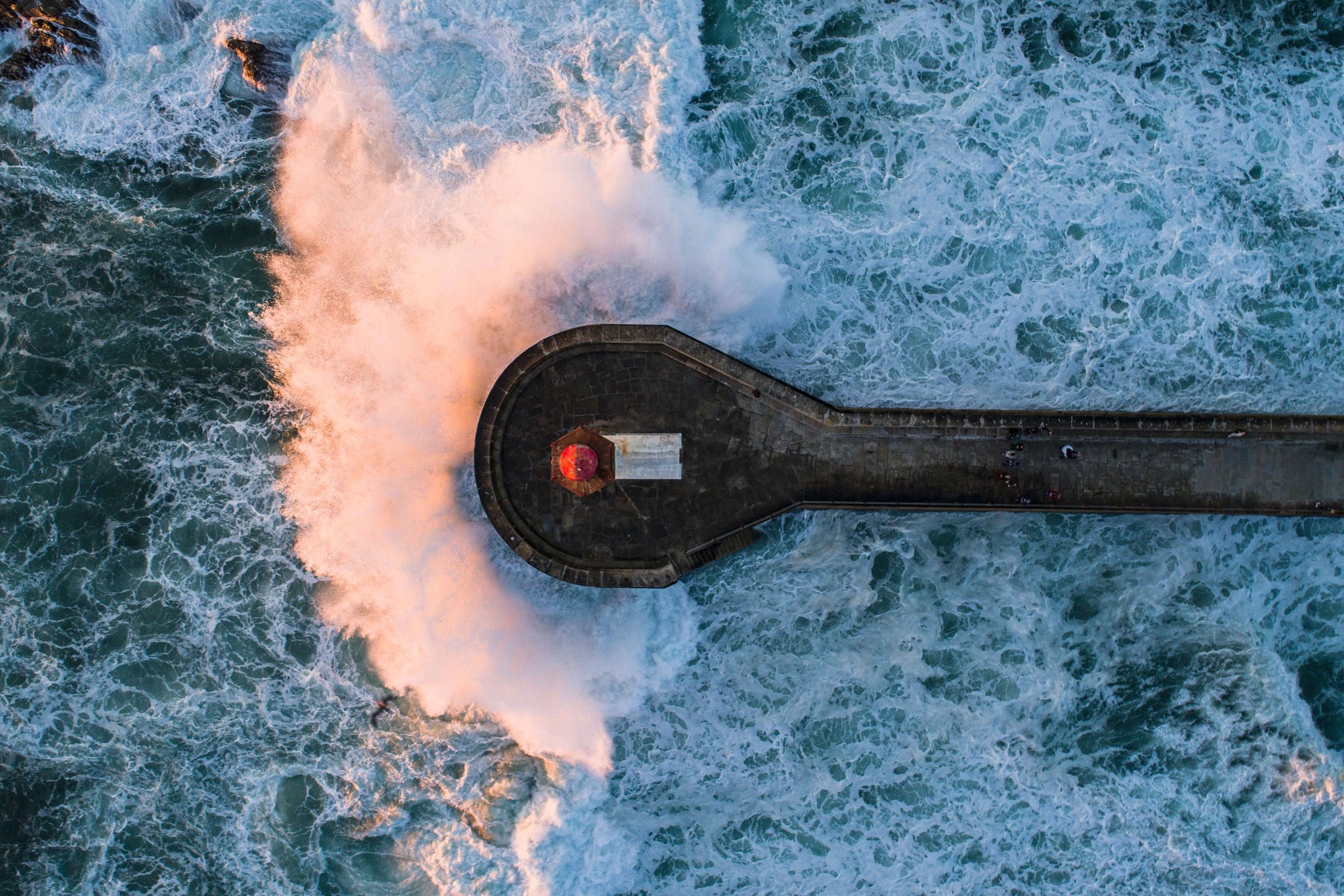 Directly above view of wave splashing on pier in sea