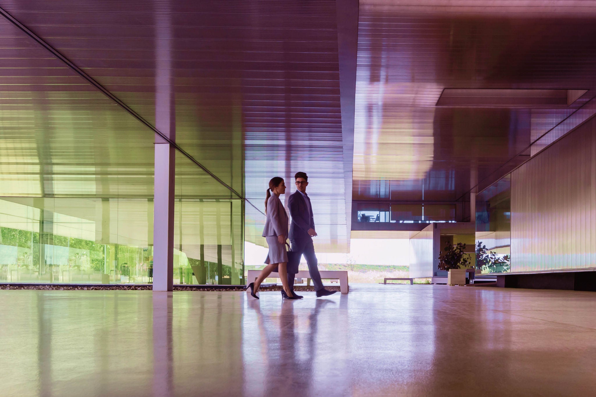 Two professionals walking through a spacious modern building