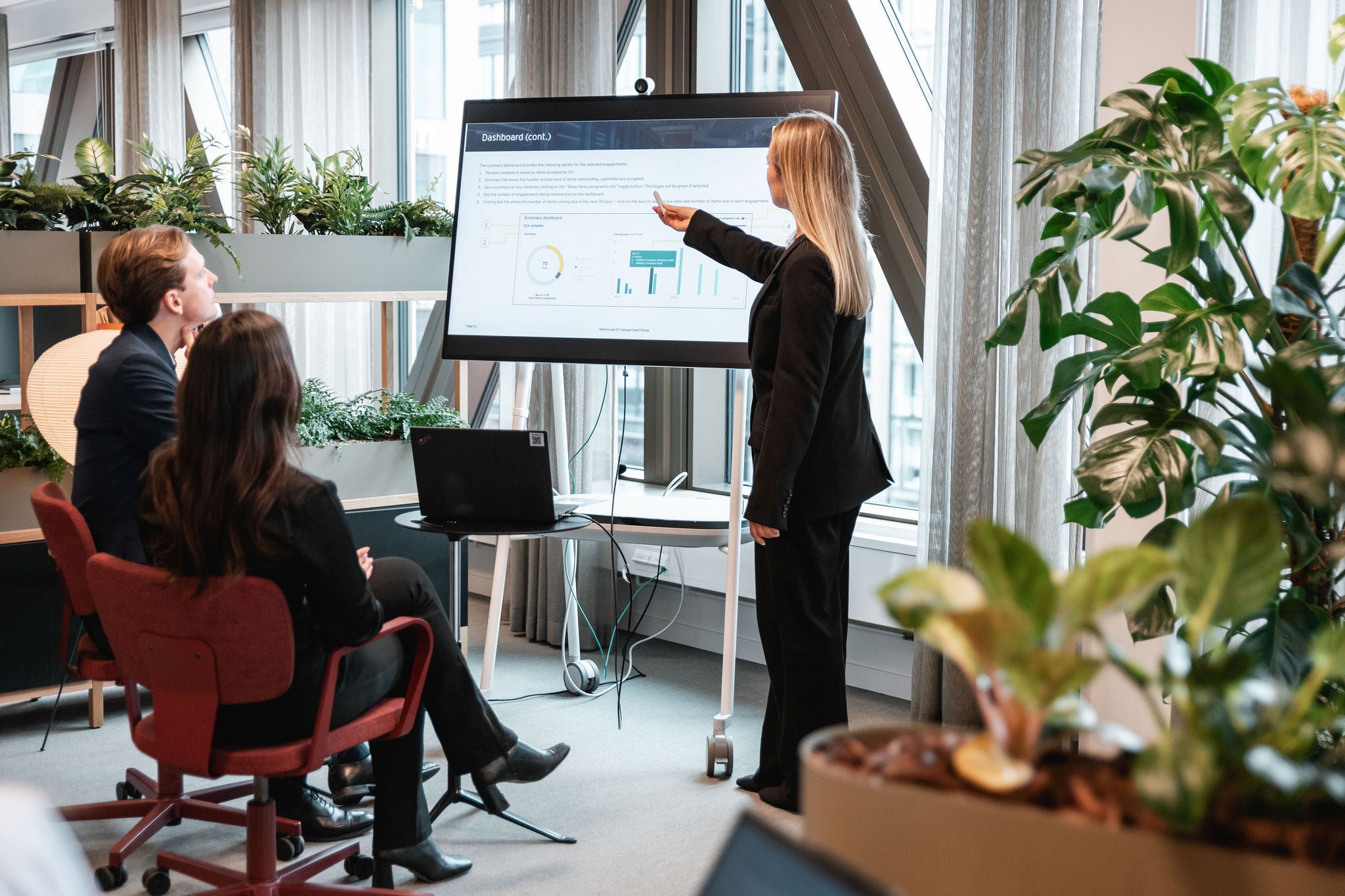 Professional presenting data on screen to team during office meeting