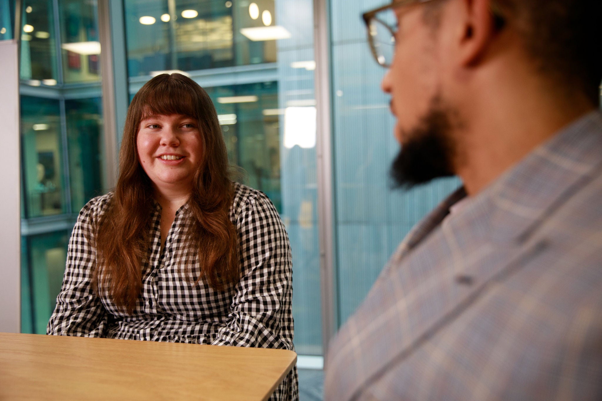 Two colleagues engaged in a discussion at a meeting table
