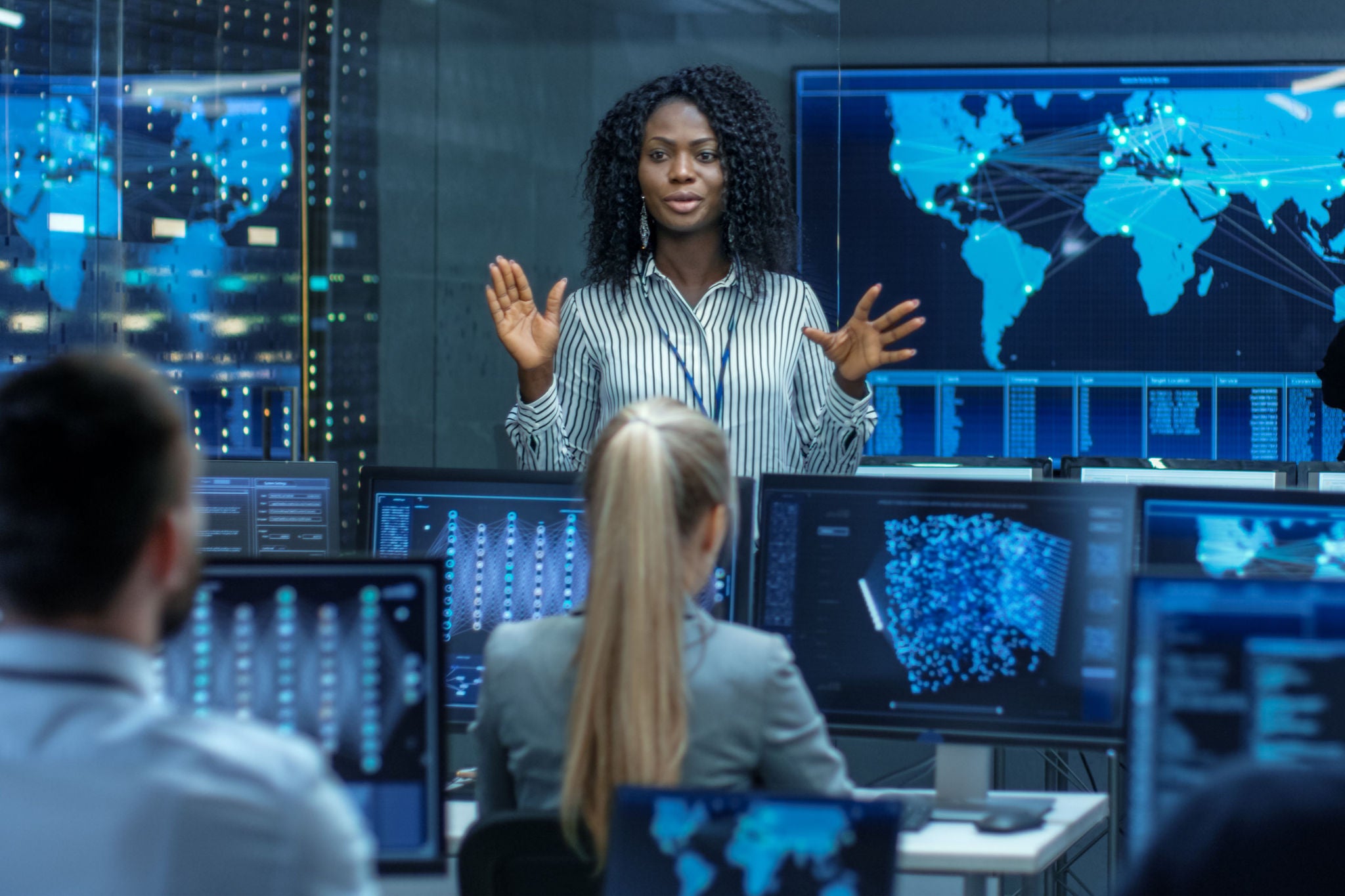 Grupo de trabajo en sala con múltiples pantallas