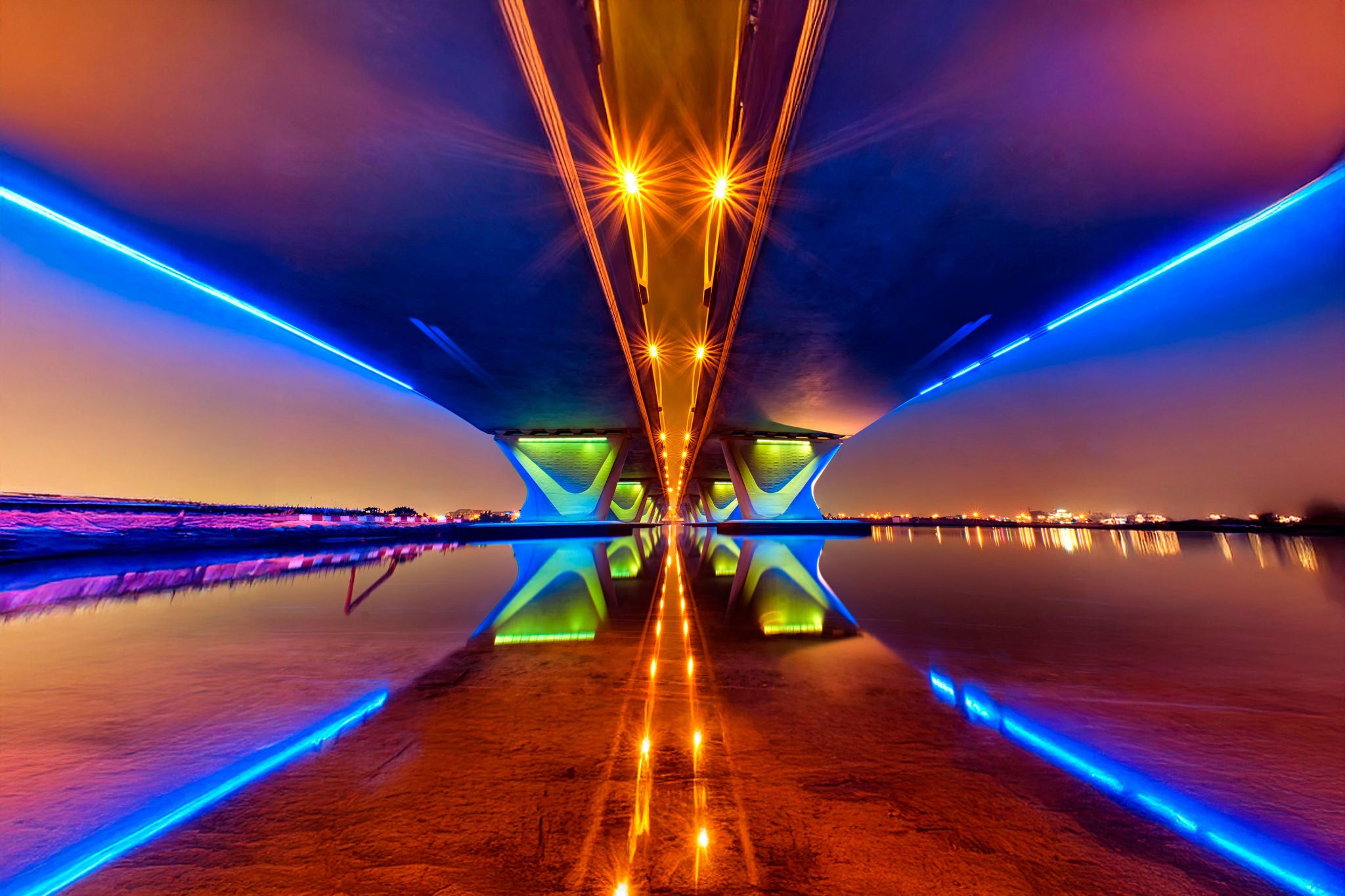 Illuminated underside of bridge at night