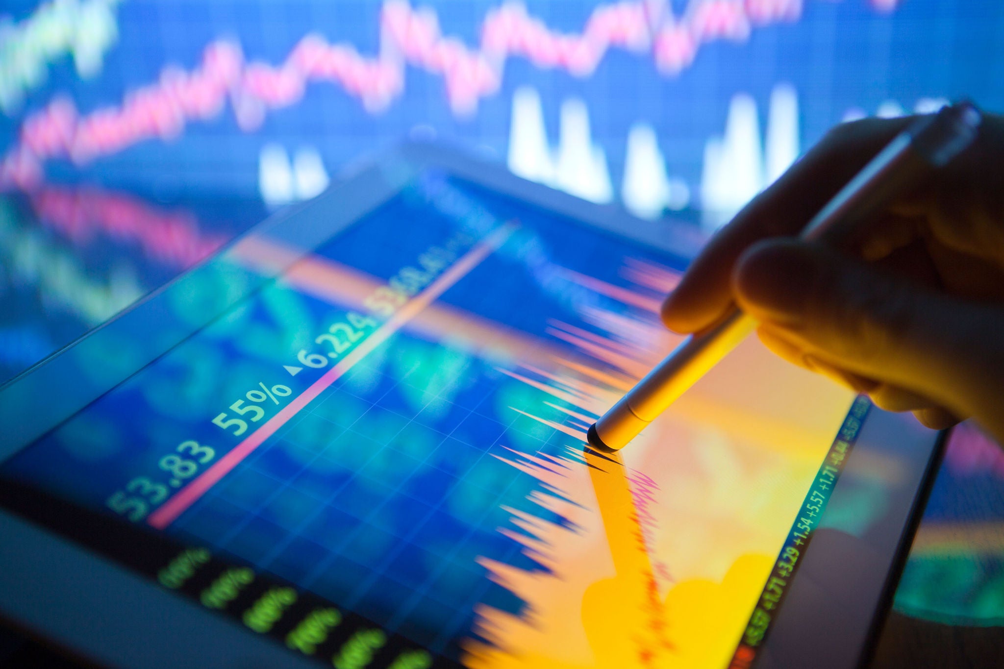 Hand analysiert bunte Finanzdaten auf einem Tablet-Bildschirm.