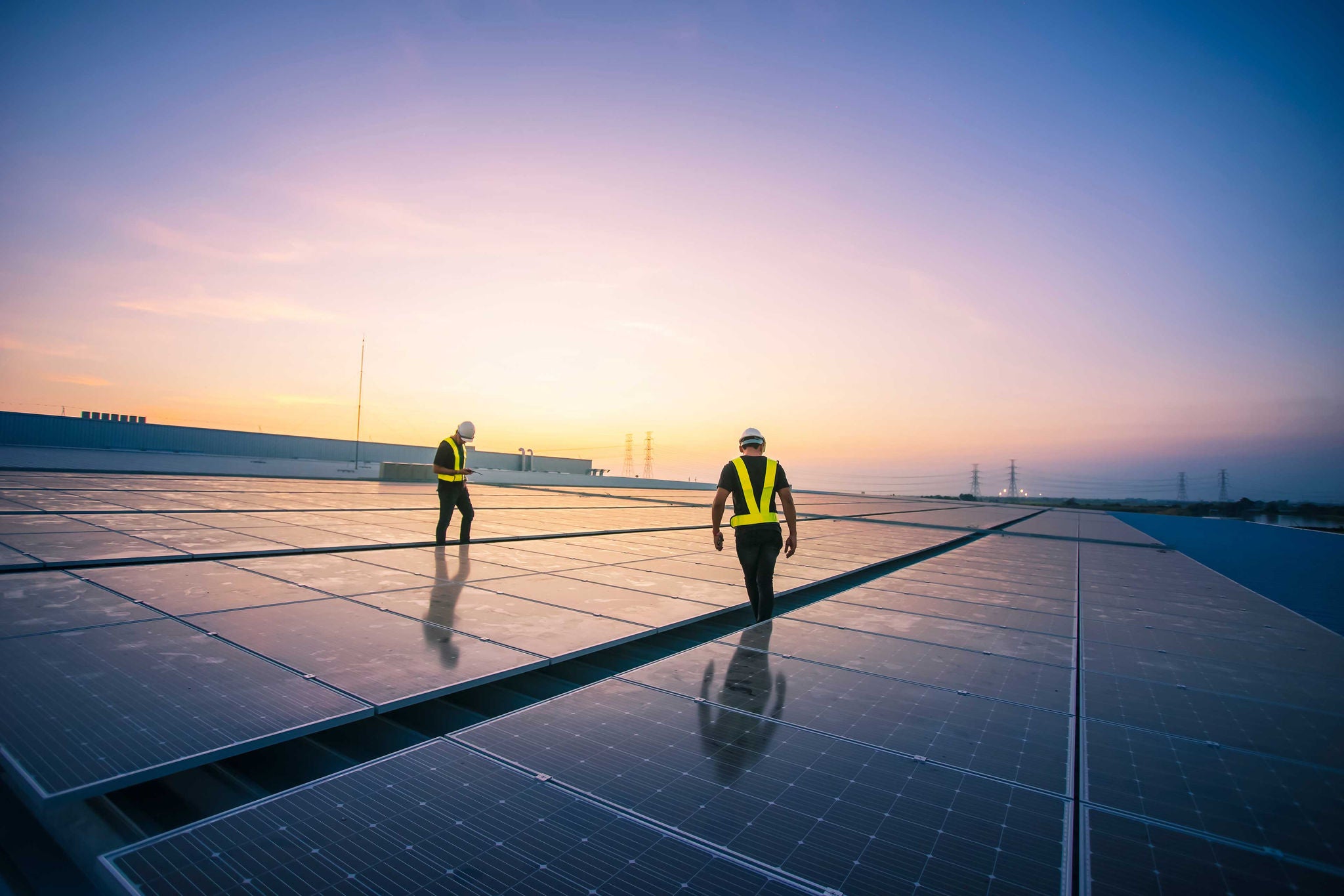 Zwei Arbeiter auf Dach mit Solarmodulen