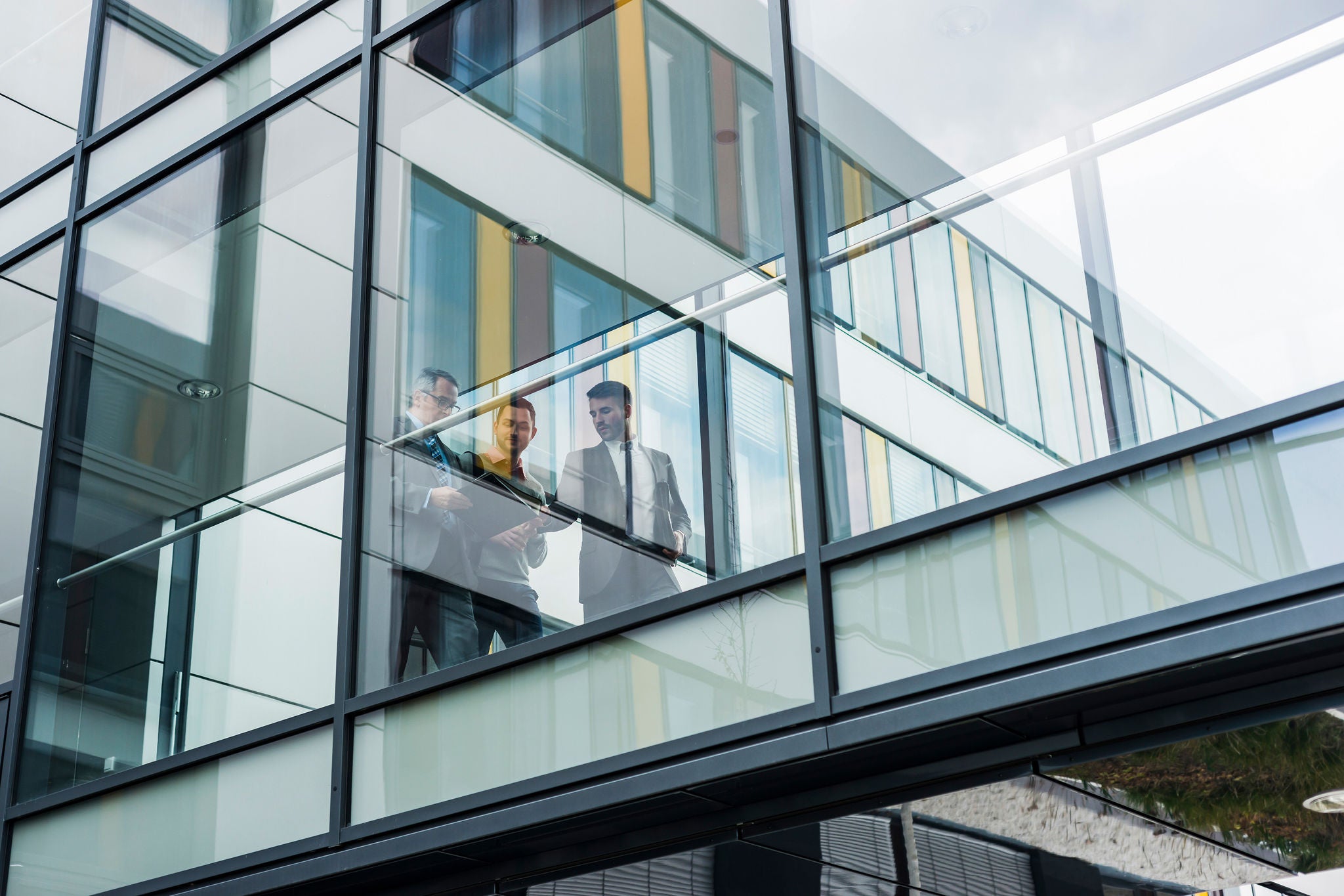 System developers analyzing code on wall screen tv looking for errors
