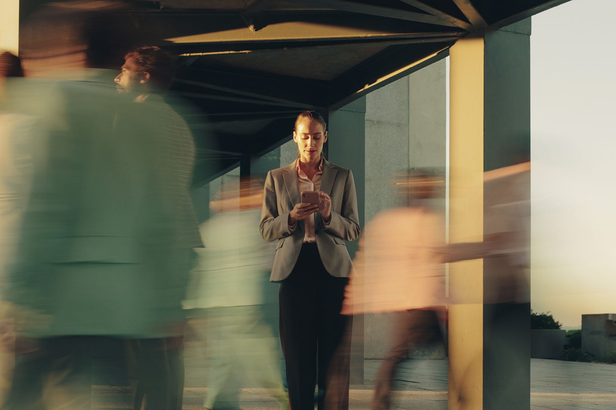 Woman standing amidst a busy office going crowed