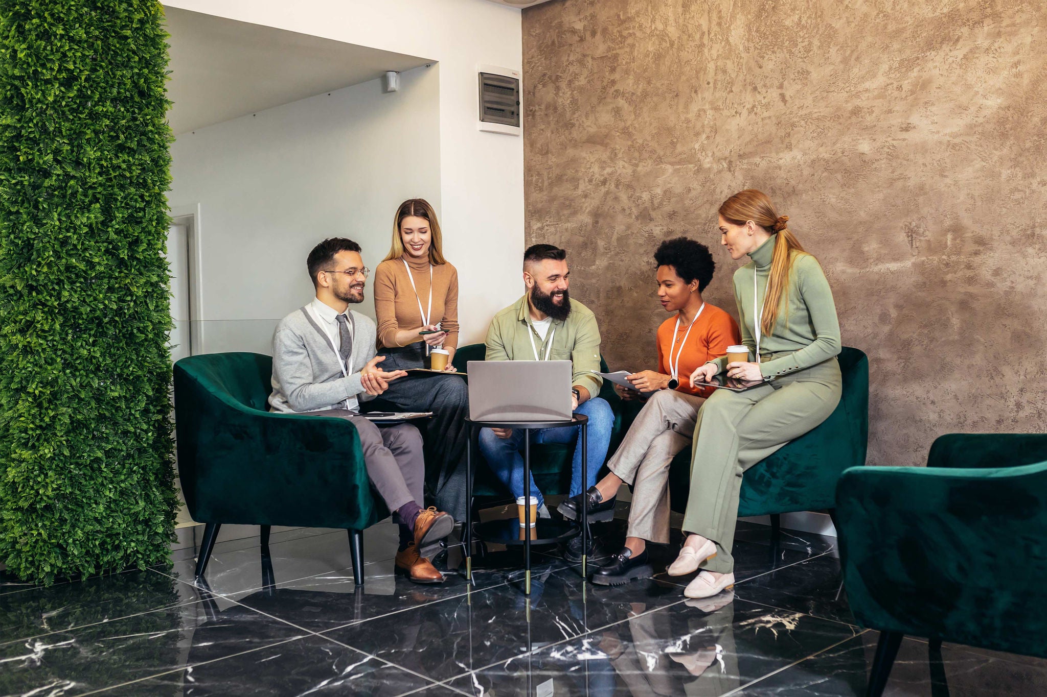 Businesspeople working in an office lobby. Group of  businesspeople sitting together in a co-working space